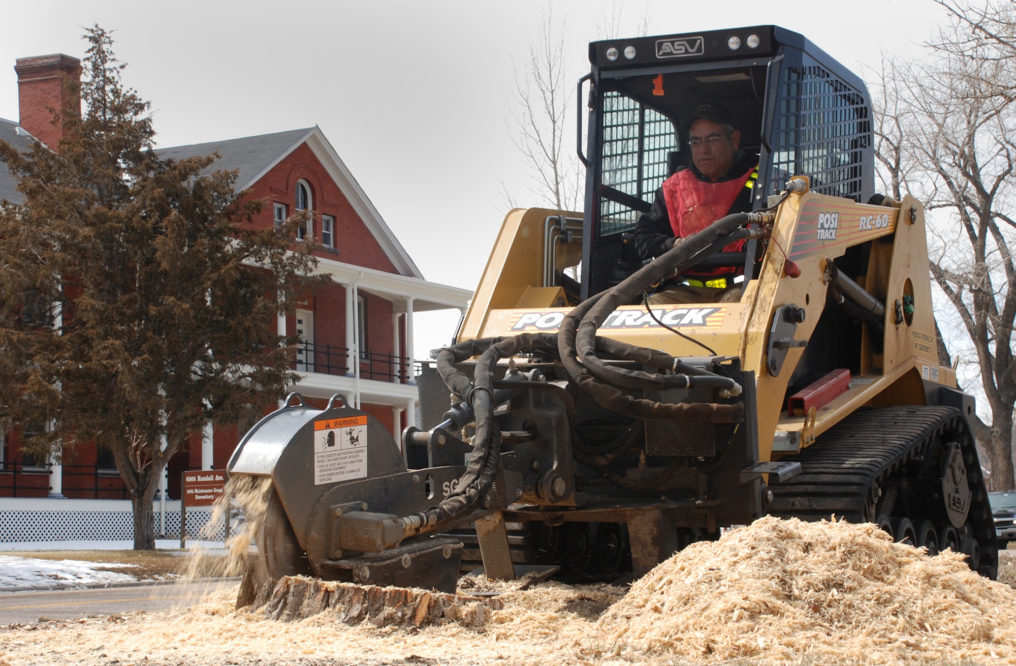 Base contractor Art Martinez operates a machine to grind a stump at a base field April 2. The over-mature tree was removed as part of an ongoing safety project (U.S. Air Force photo/Airman 1st Class Daryl Knee).
