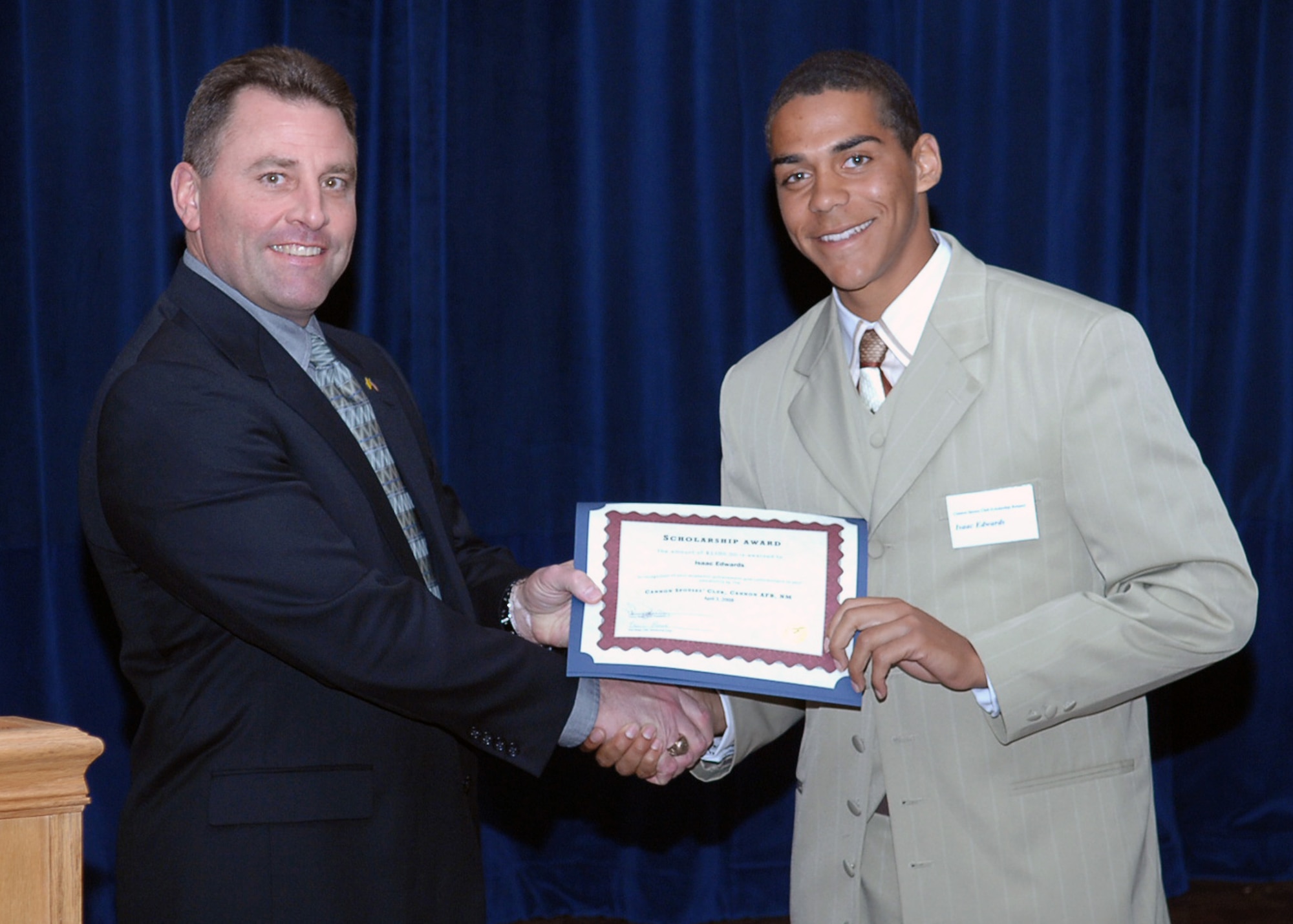 CANNON AIR FORCE BASE, N.M. -- Isaac Edwards, Clovis High School's top graduate, receives a scholarship worth $1,100 from Col. Timothy Leahy, 27th Special Operations Wing commander, April 3 at The Landing. The Cannon Spouses' Club presented eight scholarships that ranged from $50 to $1,000 to Air Force family members in the local area. (Air Force photo/Airman Basic Danielle Martin)