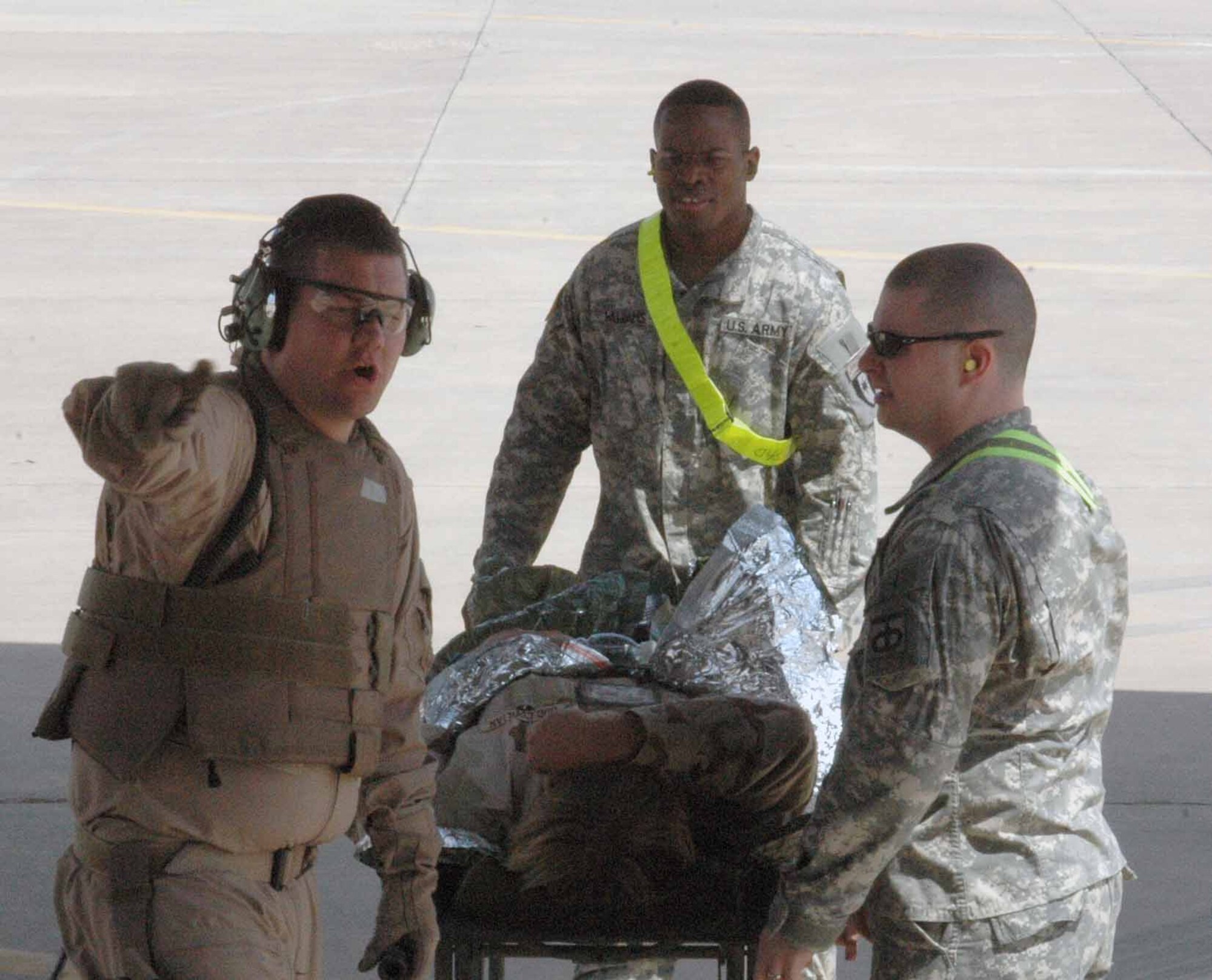 Wearing full body armor, Capt. Robert Pewitt, 379th EAES medical crew director, instructs Army medics where to place a litter patient who needed to be medically evacuated from Balad Air Base, Iraq, to the Persian Gulf region for transfer to a hospital in Germany. Captain Pewitt is a member of the Tennessee Air National Guard, deployed from the 118th Airlift Wing in Nashville, Tenn. (U.S. Air Force photo by Senior Airman Carolyn Viss)
