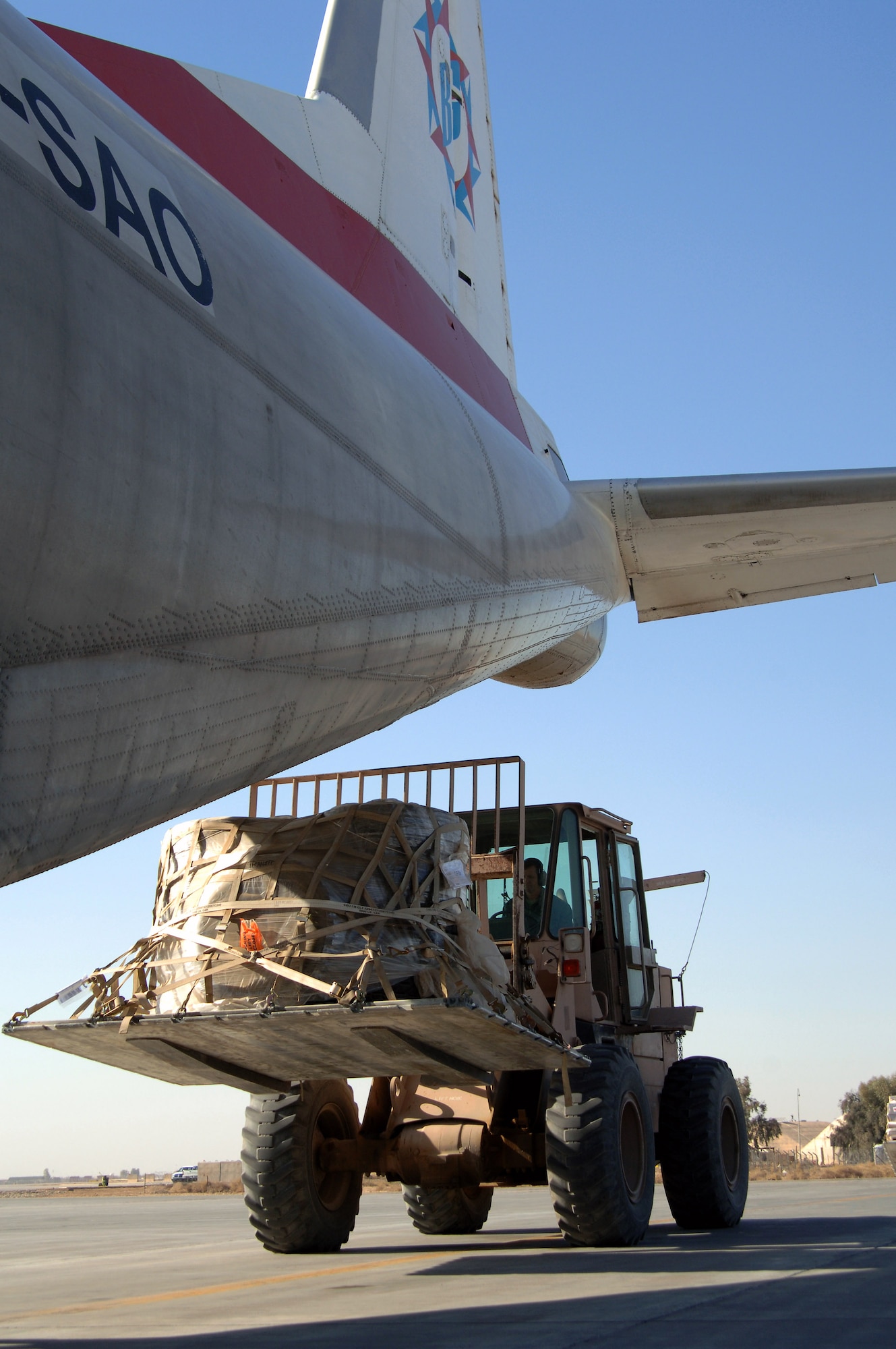 An aerial port flight ramp service technician from the 332nd Expeditionary Logistics Readiness Squadron moves a load of cargo into a commercial aircraft at Balad Air Base, Iraq.  By being able to transport cargo, personnel and supplies by aircraft, fewer military vehicle convoys are required to transport cargo over dangerous roads.  (U.S. Air Force photo/Master Sgt. Heather Cabral)