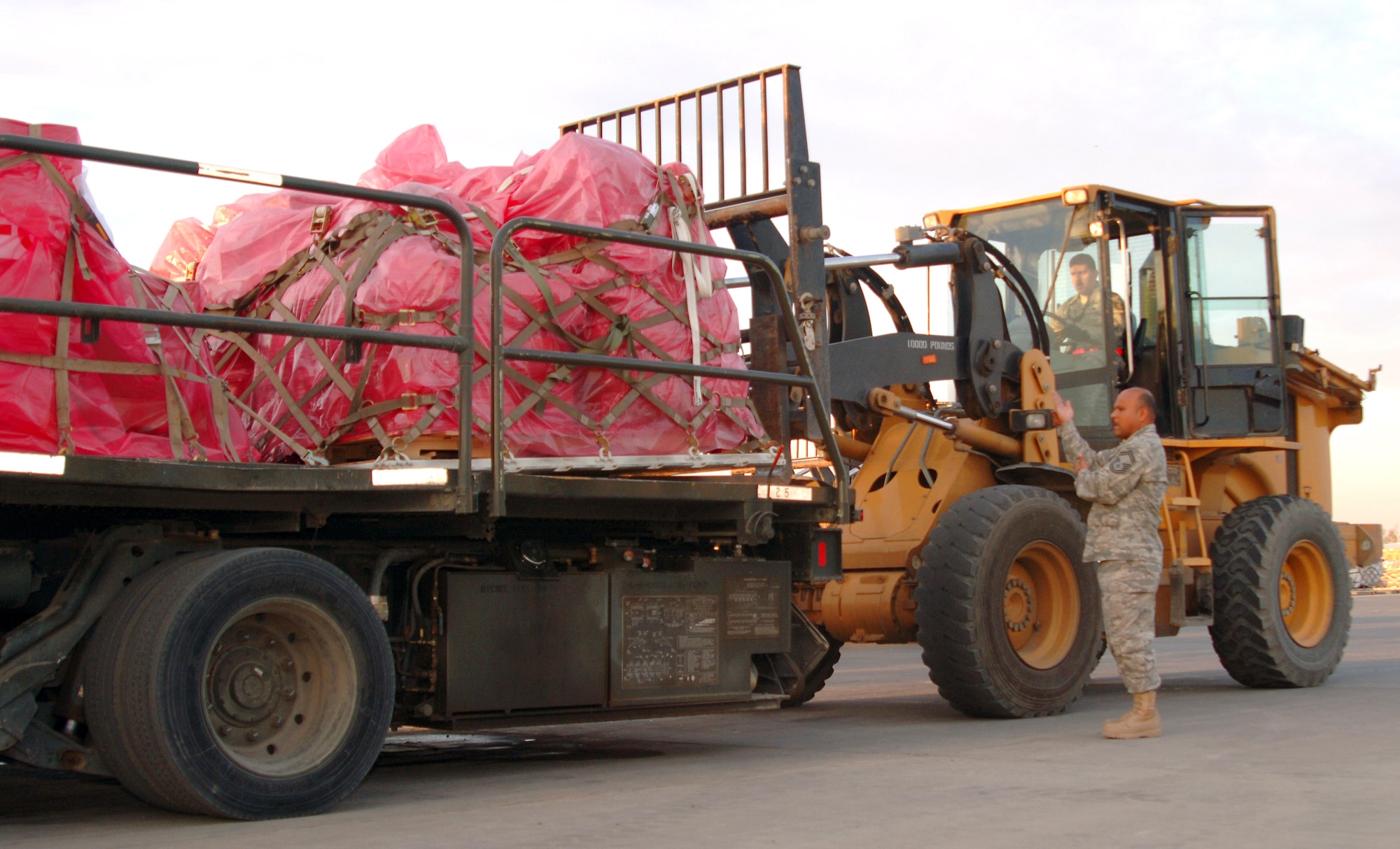 Senior Master Sgt. Richard Garcia helps Tech. Sgt. Modesto Guevara line up his forklift to pick up cargo at Balad Air Base, Iraq.  Both sergeants, aerial port flight ramp service technicians with the 332nd Expeditionary Logistics Readiness Squadron, are reservists deployed from the 26th Aerial Port Squadron at Lackland Air Force Base, Texas.  (U.S. Air Force photo/Master Sgt. Heather Cabral)