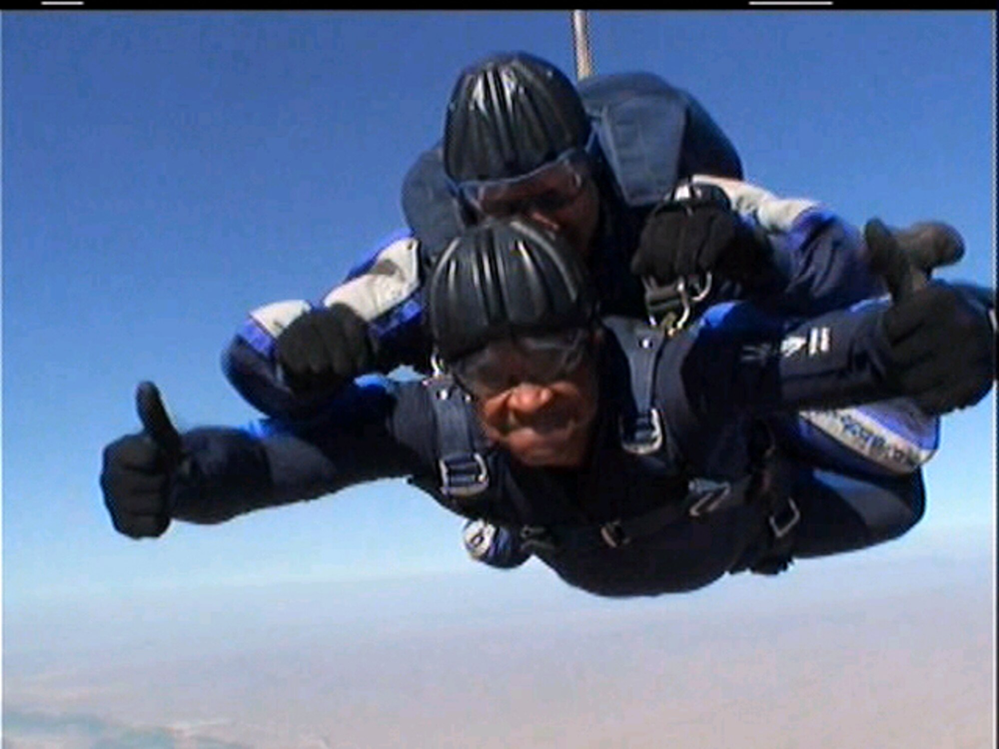 SEYMOUR JOHNSON AIR FORCE BASE, N.C. -- Tech. Sgt. Adolphus Grisby (bottom), a services craftsman with the 916th Services Flight, demonstrates that he is willing to jump out of a perfectly good airplane. The Air Force Reservist recently supported the Wings of Blue program at Luke Air Force Base, AZ. The program is for Air Force Academy cadets trying out for the sky diving team. Sergeant Grisby, and four other services personnel from the 916th, were able to parachute tandum-style with the instructors.