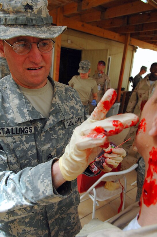 Army Sgt. Robert Stallings applies moulage to the face of Tech. Sgt. Yvonne Lough to bring an element of realism to a mass casualty battle drill March 31 at Balad Air Base, Iraq. The battle drill tested the ability of base members to respond and react to a mass casualty event by coordinating assets, patient movement and execution procedures. Sergeant Stallings is assigned to the 325th Combat Support Hospital medic and deployed from Hanscom Air Force Base, Mass. Sergeant Yvonne Lough is a 332nd Expeditionary Medical Operations Squadron respiratory therapist deployed from Kessler AFB, Miss. (U.S. Air Force photo/Senior Airman Senior Airman Julianne Showalter) 