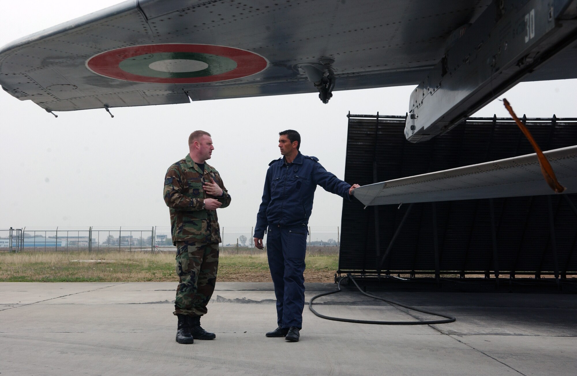 GRAF IGNATIEVO AIR BASE, Bulgaria -- Staff Sgt. Robert Jackson and Bulgarian air Force Master Sgt. Vladimir Kolev, dedicated crew chiefs for F-15 and MiG-29 aircraft respectively, discuss the differences and similarities in maintainance procedures for their planes. As part of a familiarization program, a few Airmen from each country's service were allowed to tour and learn about each other's aircraft. Sergeant Jackson is deployed here as part of Operation Noble Endeavor.  (U.S. Air Force photo by Tech. Sgt. Jill LaVoie)