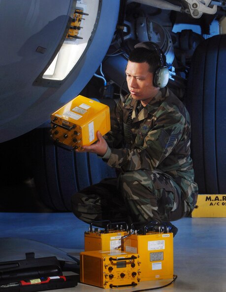 Tech. Sgt. Truong Nguyen installs an AN/ALM-288 countermeasures test set on a C-17 Globemaster III cargo aircraft April 2 at March Air Reserve Base, Calif.  Sergeant Nguyen is an electronic warfare technician with the Air Force Reserve.  (U.S. Air Force photo/Val Gempis)