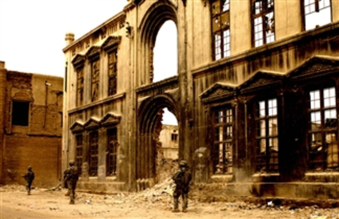 Soldiers assigned to the U.S. Army 3rd Squadron, 89th Cavalry Regiment, Headquarters Headquarters Troop, 4th Brigade, 10th Mountain Division patrol past the facade of a demolished building in Baghdad, Iraq, on March 27, 2008.  
