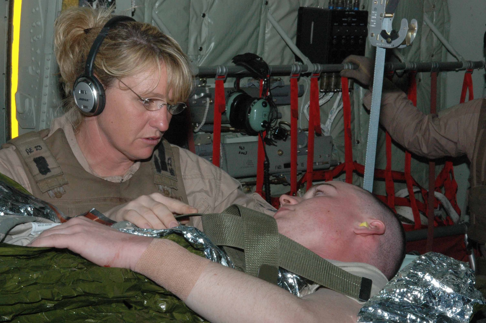 Capt. Lisa Causey, 379th Expeditionary Aeromedical Evacuation Squadron second flight nurse, cares for a litter patient on board a C-130J , April 2, 2008. As an Air National Guard member deployed from the 183rd Aeromedical Evacuation Squadron in Jackson, Miss., she, along with four other medical specialists and a team of pilots and loadmasters, made a 15-hour flight to four cities in Iraq and one air base in the Middle East. They airlifted 19 patients, 16 of whom were ambulatory, to the Persian Gulf, where most of the patients were transferred to a C-17 headed for Germany. (U.S. Air Force photo by Senior Airman Carolyn Viss)