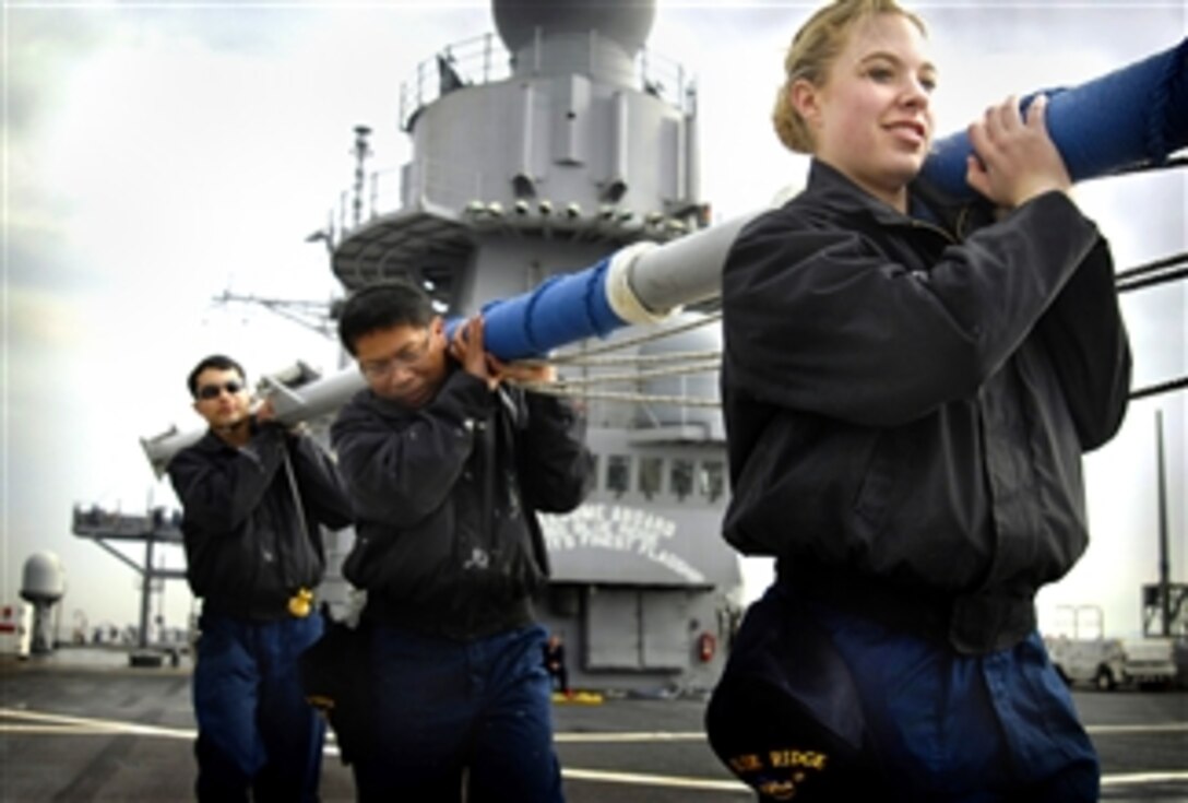 U.S. Navy Seaman Mellisa J. Oakes guides fellow seamen as they carry a flag staff across the flight deck of the amphibious command ship USS Blue Ridge, Pacific Ocean, April 4, 200. Blue Ridge is the flagship for Commander, U.S. 7th Fleet.