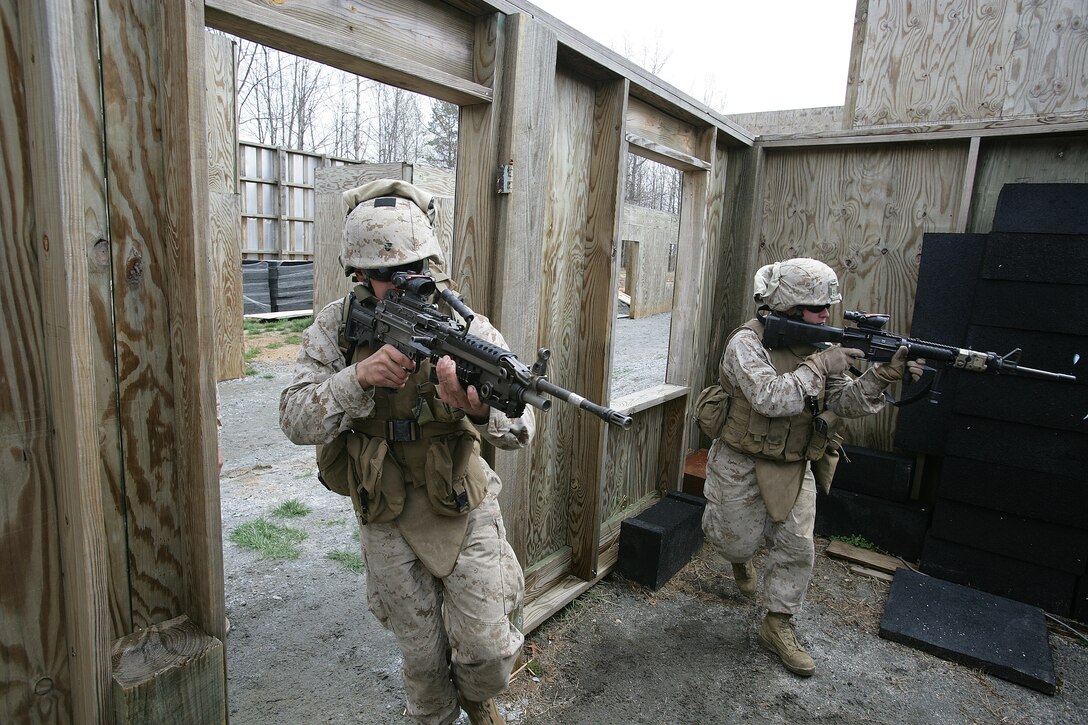 Lance Cpl. Joseph Lourenco and Pfc. Daniel Bolsar clear a room during a portion of the urban assault course at Fort Pickett here today. The live-fire training was held to prepare Battalion Landing Team, 2nd Battalion, 6th Marine Regiment's Company E for their upcoming deployment this fall.