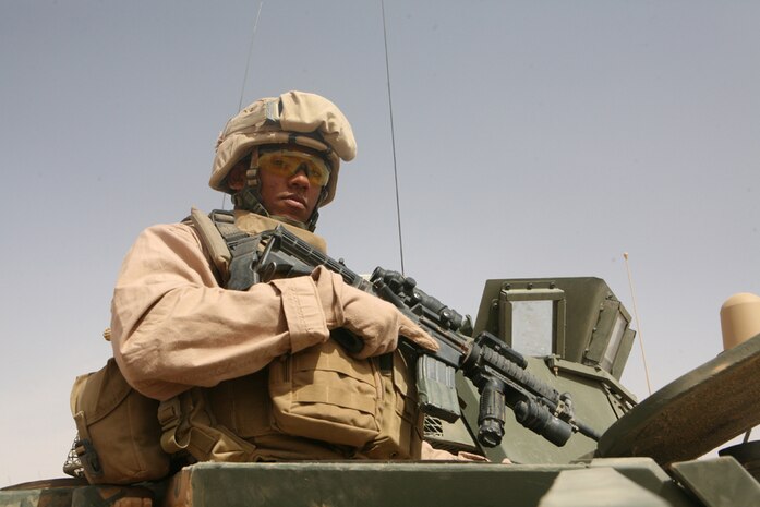 Cpl. Andrew M. Oquendo, a scout with 2nd Light Armored Reconnaissance Battalion, Regimental Combat Team 5, pops out of his light armored vehicles' scout hatch at Camp Korean Village, Iraq, April 16. From photographer to infantryman, the 22-year-old from Paterson, N.J., separated from the U.S. Air Force to join the U.S. Marine Corps. "I knew what I really wanted to do, so I had to do whatever it took to achieve it," said Oquendo.