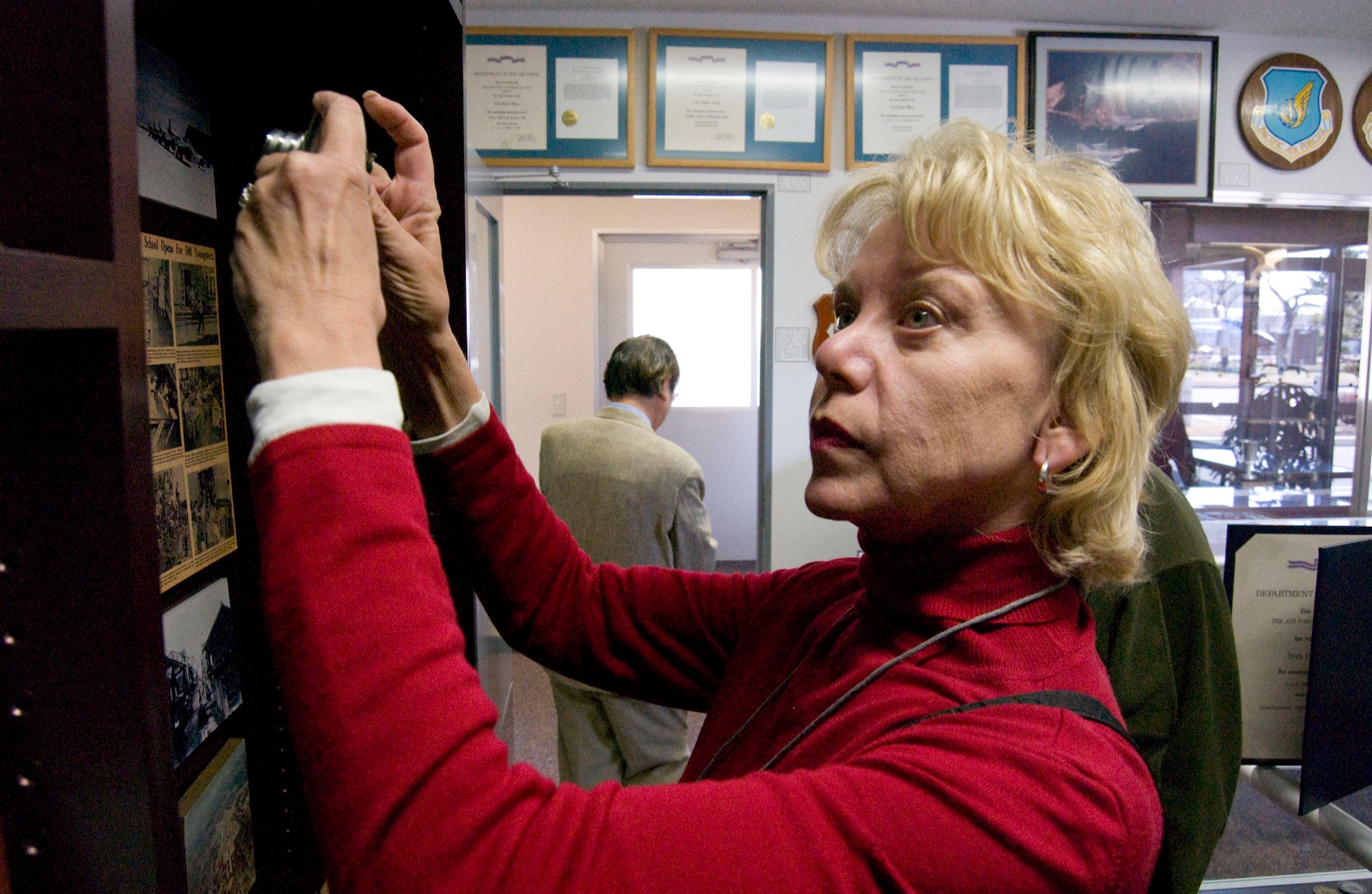 MISAWA AIR BASE, Japan -- Sharon Govern from California takes a snapshot of a display in the Heritage Room at the 35th Fighter Wing headquarters on April 2, 2008. Mrs. Govern is an alumnus of Edgren High School, the Department of Defense high school at Misawa Air Base, and returned with fellow alumni as part of an annual trip to visit their alma mater. (U.S. Air Force photo by Senior Airman Samuel Morse)