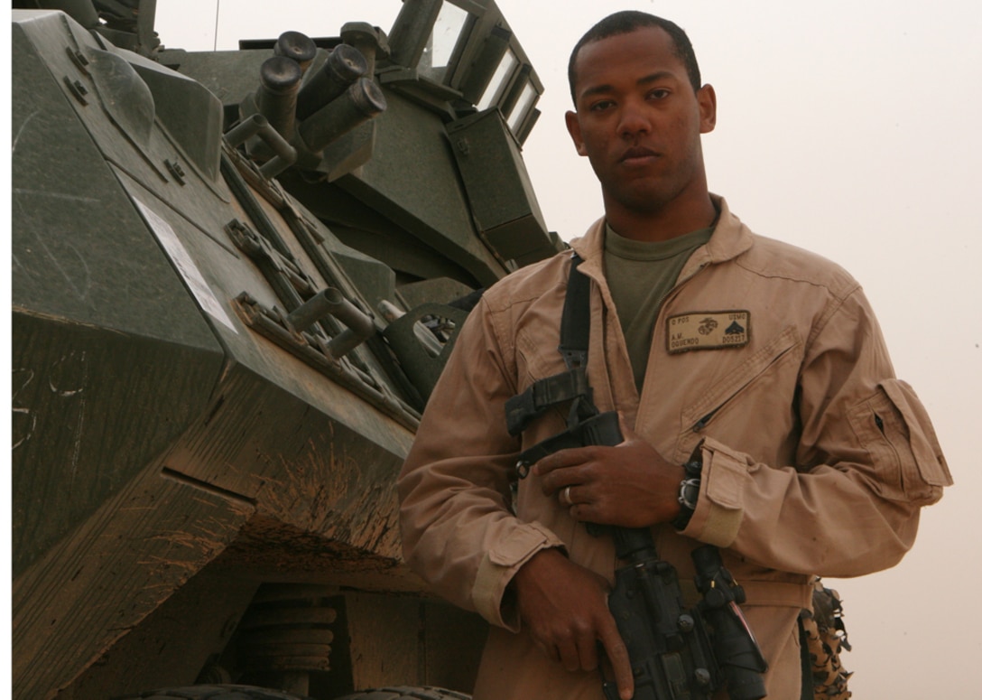 Cpl. Andrew M. Oquendo, a scout with Delta Company, 2nd Light Armored Reconnaissance Battalion, Regimental Combat Team 5, stands in front of a light armored vehicle at Camp Korean Village, Iraq, April 16. Oquendo, 22, from Paterson, N.J., joined the Marine Corps infantry after being a photographer for the U.S. Air Force. "I wanted to be a Marine ever since I joined the military," said Oquendo. "I worked hard to get where I am today, and it is extremely rewarding in every aspect."