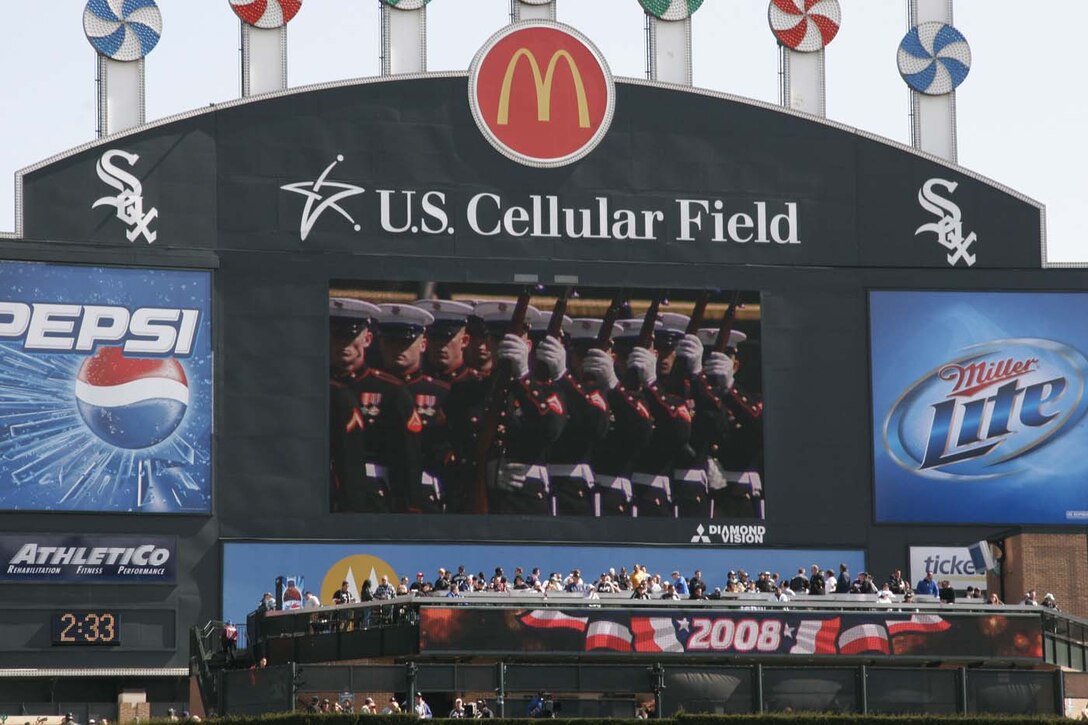 Marines of the Silent Drill Platoon apear on the large video screen while performing at the Chicago White Sox home opener April 7.