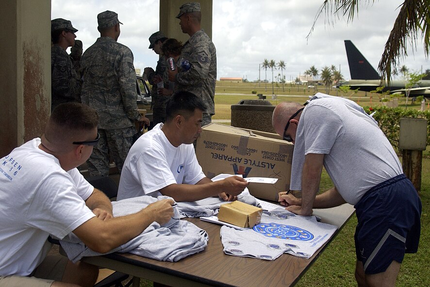 Technical Sergeant Christopher Tuggle, 36th Civil Engineering squadon, with a Network 5/6 t-shirt over one shoulder signs up to part of the network at the Network 5/6 Icebreaker held Apr. 4 at Arc Light Memorial. (U.S. Air Force photo by Airman 1st Class Carissa Wolff)  
