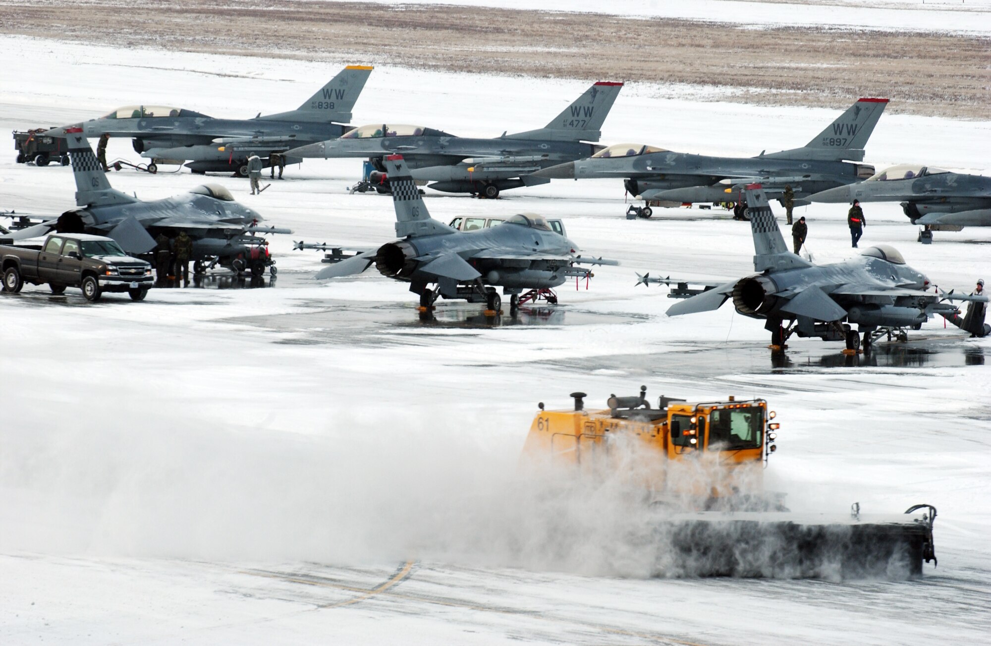 A snow removal vehicle clears a path on the tarmac for aircraft to taxi for the first official day of Red Flag-Alaska 08-2 April 7 at Eielson Air Force Base, Alaska. Red Flag-Alaska provides training for deployed maintenance and support personnel in sustainment of a large-force deployed air operation. He is assigned to the Royal Australian Air Force. The aircraft are assigned to the 36th Fighter Squadron of Osan Air Base, Korea. (U.S. Air Force Photo/Airman 1st Class Jonathan Snyder)