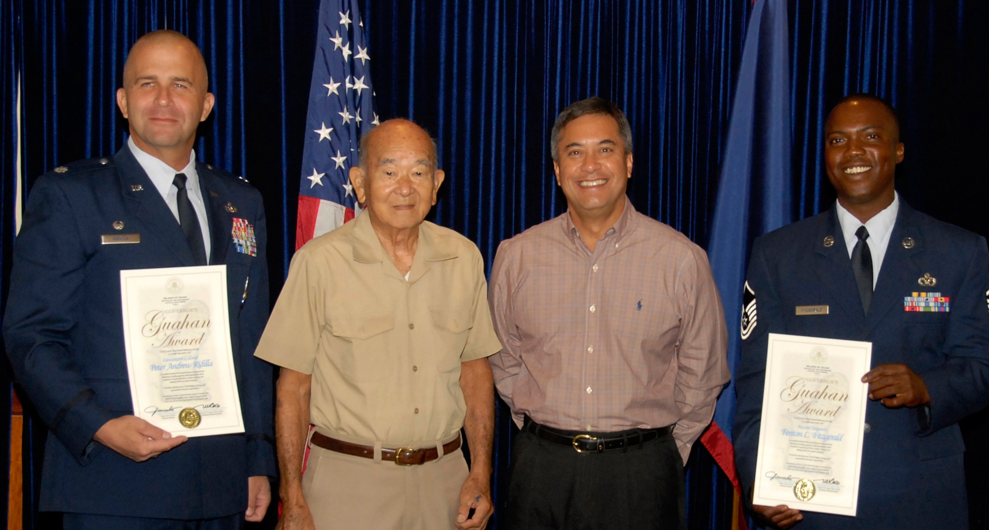 Governor Felix P. Camacho presents Lt. Col. Peter Ridilla, 36th Civil Engineer Squadron commander and Master Sgt. Fenton Fitzgerald, also from the 36th CES, with the Governor's Gauhan Award on March 27 at the Governor's Complex in Haganta. Given by the people of Guam, the award recognizes positive contributions made in communities throughout the island. (U.S. Air Force photo by Airman 1st Class Nichelle Griffiths)