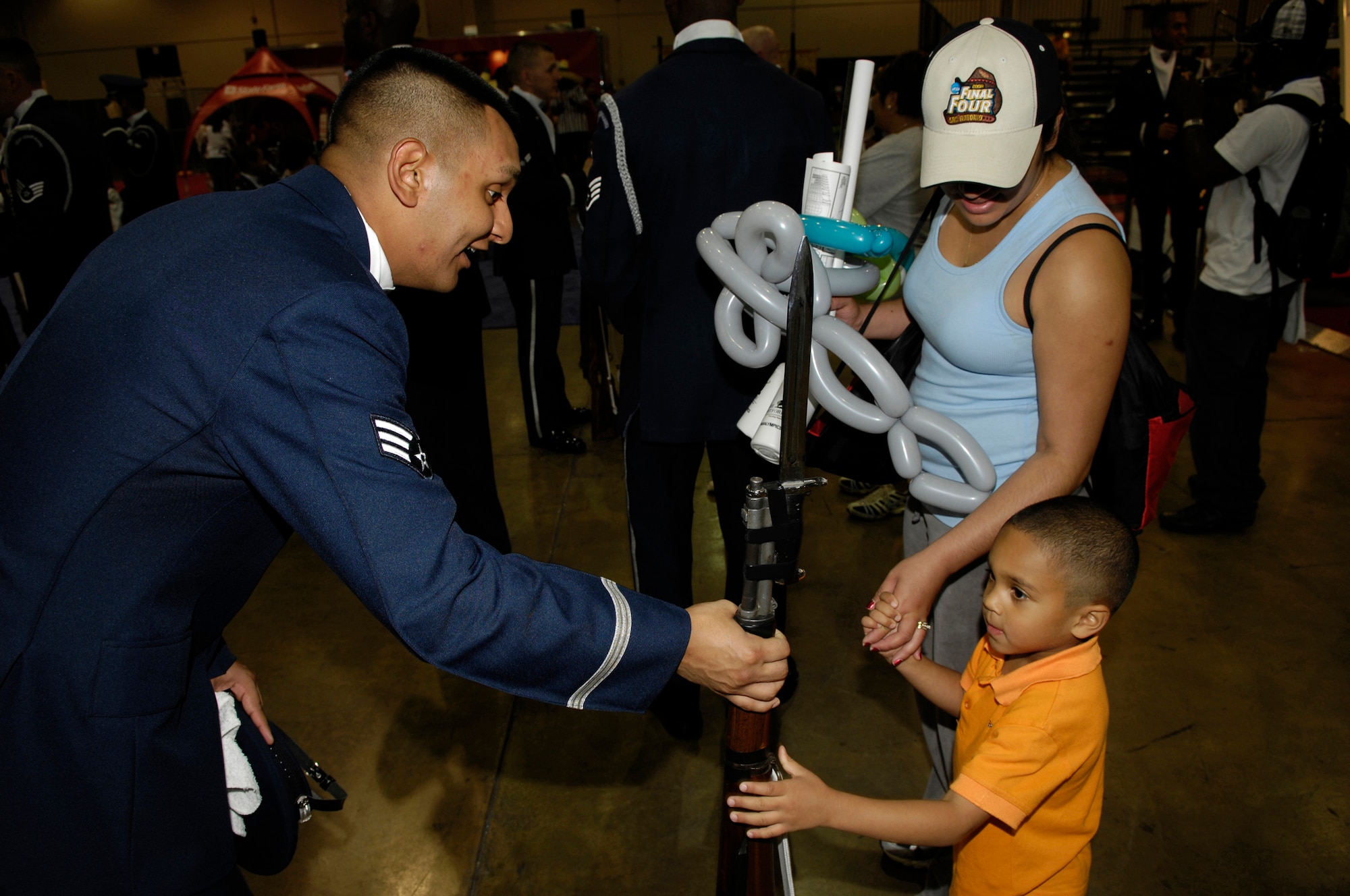 Senior Airman David Perry, USAF Honor Guard Drill Team member, interacts with a young NCAA college basketball fan following the Drill Team's performance at Hoop City. The Drill Team is the travelling component of the Air Force Honor Guard and tours worldwide showcasing the precision of today's Air Force, to recruit, retain and inspire Airmen for the Air Force mission. (U.S. Air Force photo by SSgt Raymond Mills)