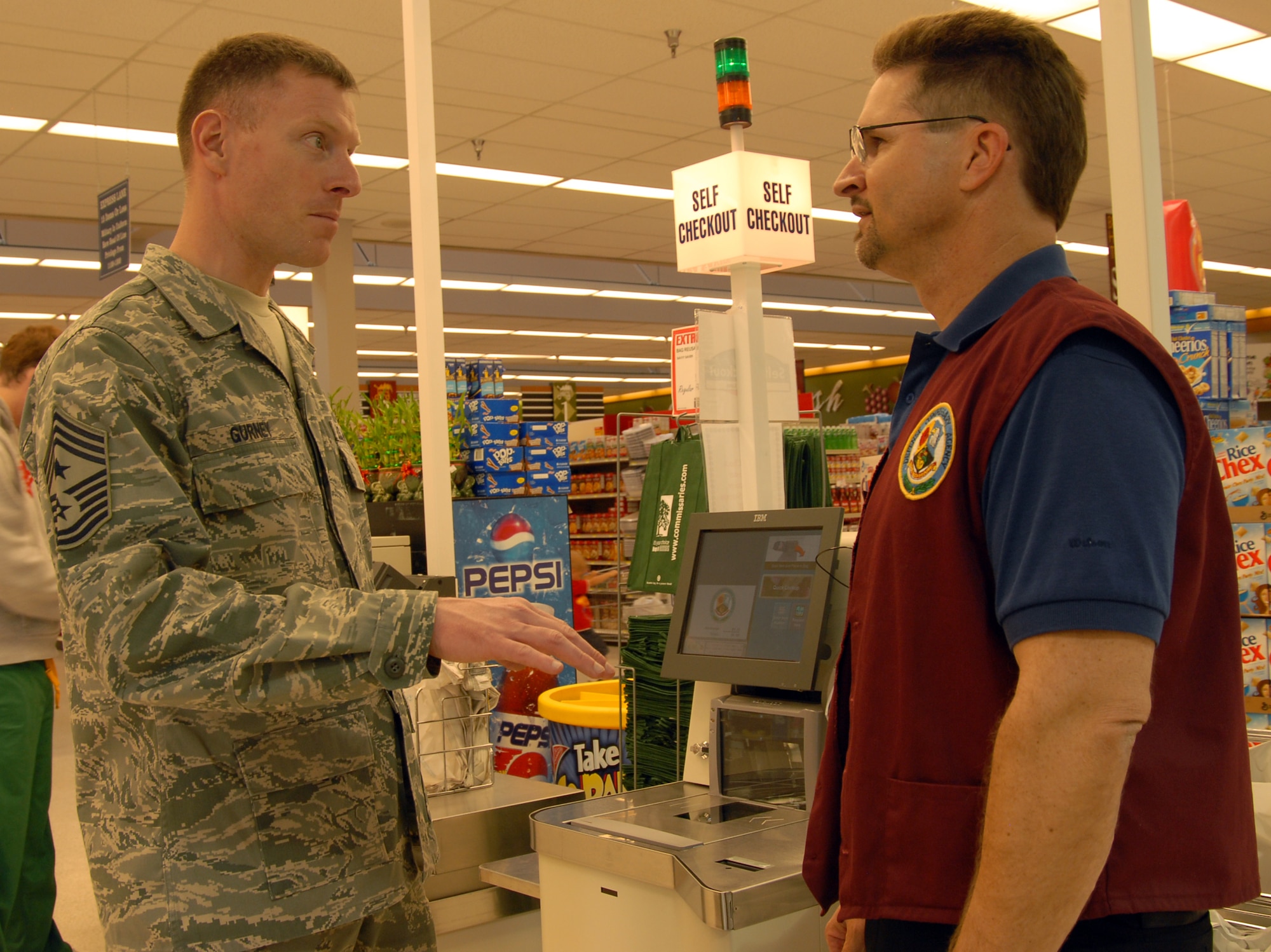 Andrew Brooks, Edwards Commissary store director, shows Chief Master Sgt. William Gurney, Air Force Materiel Command command chief, the new self-checkout aisle at the Commissary here April 4. Chief Gurney recieved the tour prior to his being the guest speaker at the Team Edwards Chief Recognition Ceremony that evening. (Air Force photo by Senior Airman Stacy Sanchez) 