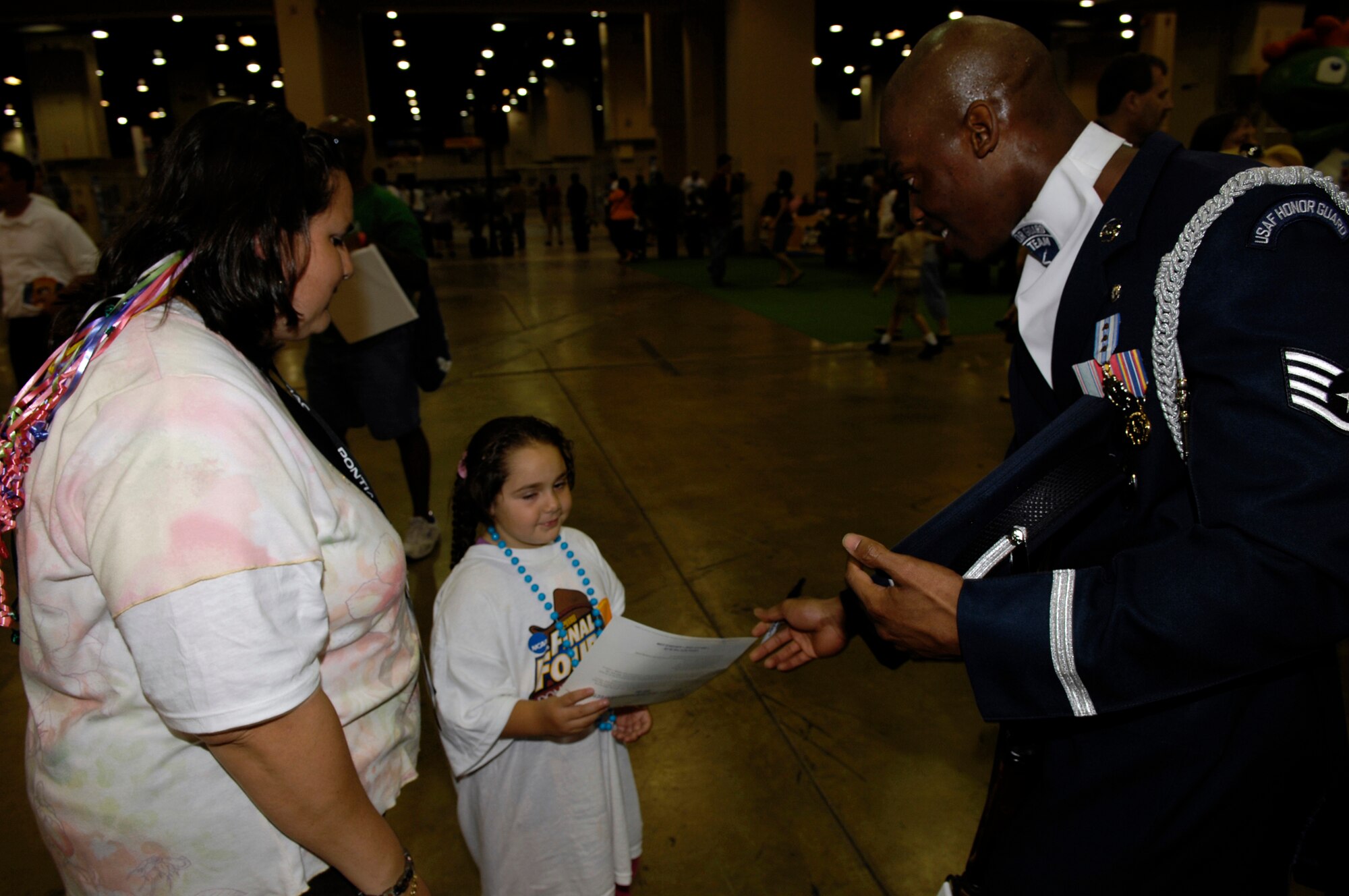 Staff Sgt. Theodore Miller, USAF Honor Guard Drill Team NCOIC, autographs an Air Force info card for an enthusiastic NCAA Men's Final Four fan in San Antonio, Texas. The Drill Team is the travelling component of the Air Force Honor Guard and tours worldwide showcasing the precision of today's Air Force, to recruit, retain and inspire Airmen for the Air Force mission. (U.S. Air Force photo by SSgt Raymond Mills)