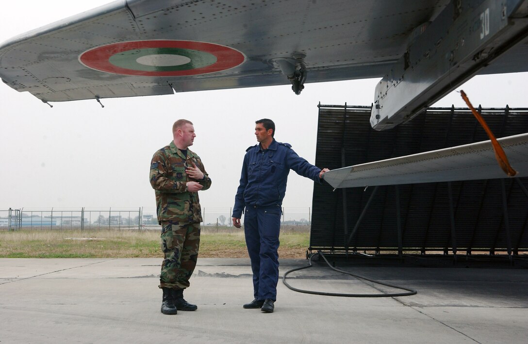 Staff Sgt. Robert Jackson and Bulgarian air force Master Sgt. Vladimir Kolev discuss the differences and similarities in maintainance procedures for their planes April 2 at Graf Ignatievo Air Base, Bulgaria. As part of a familiarization program, a few Airmen from each country's service were allowed to tour and learn about each other's aircraft. Sergeant Jackson is deployed here as part of Operation Noble Endeavor. Sergeant Jackson, an F-15 Eagle crew chief, is deployed for Operation Noble Endeavor. Sergeant Kolev is a MiG-29 crew chief. (U.S. Air Force photo/Tech. Sgt. Jill LaVoie) 