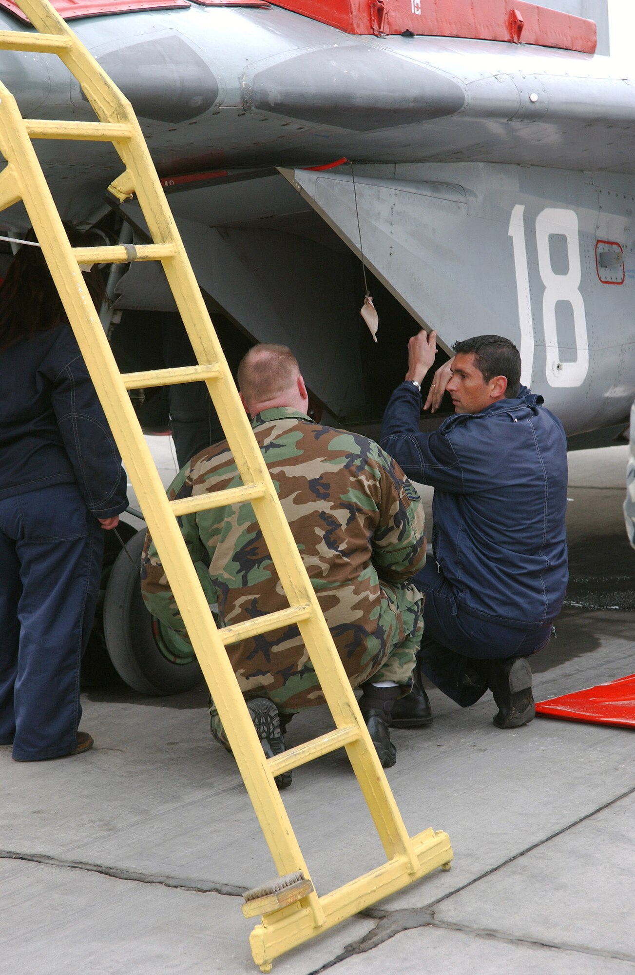 Bulgarian air force Master Sgt. Vladimir Kolev briefs Staff Sgt. Robert Jackson on MiG-29 maintenance procedures April 2 at Graf Ignatievo Air Base, Bulgaria. As part of a familiarization program, a few U.S. Air Force Airmen were allowed to tour a MiG-29 and watch Bulgarian airmen perform a depot inspection. Sergeant Jackson, an F-15 Eagle crew chief, is deployed for Operation Noble Endeavor. Sergeant Kolev is a MiG-29 crew chief. (U.S. Air Force photo/Tech. Sgt. Jill LaVoie) 

