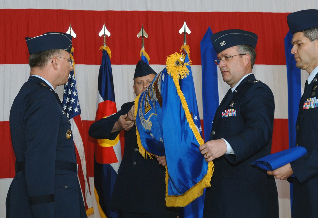 Col. Jeff Ansted, newly installed commander of the Air Force Reserve's 310th Space Wing, unfurls the wing's colors during an activation ceremony April 4 at Peterson Air Force Base, Colo.  Lt. Gen. John Bradley, left, chief of Air Force Reserve and commander of Air Force Reserve Command, officially stood up the AFRC's first-ever space wing. The 310th provides its gaining major command, Air Force Space Command, with experienced people in seven space squadrons to man space-based systems including Defense Meteorological satellites for weather observation, Midcourse Space Experiment satellite to conduct space surveillance, the Space-Based Infrared System for early missile warning and Global Positioning System satellites used for navigation.  The wing also includes a test squadron, several base support squadrons, medical staff and the Reserve National Security Space Institute.  In all, ten squadrons, five stand-alone flights and the institute report to the 310th SW.(U.S. Air Force Photo/Amber K. Whittington)