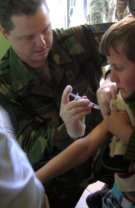 Master Sgt. David Morrison administers the Hepatitis A shot to an Albanian boy in February in Albania. Sergeant Morrison, along with four other 109th Airlift Wing medics from the Stratton Air National Guard Base in New York, administered 1,000 Hepatitis A shots during a humanitarian mission with the New Jersey National Guard. (Courtesy photo) 