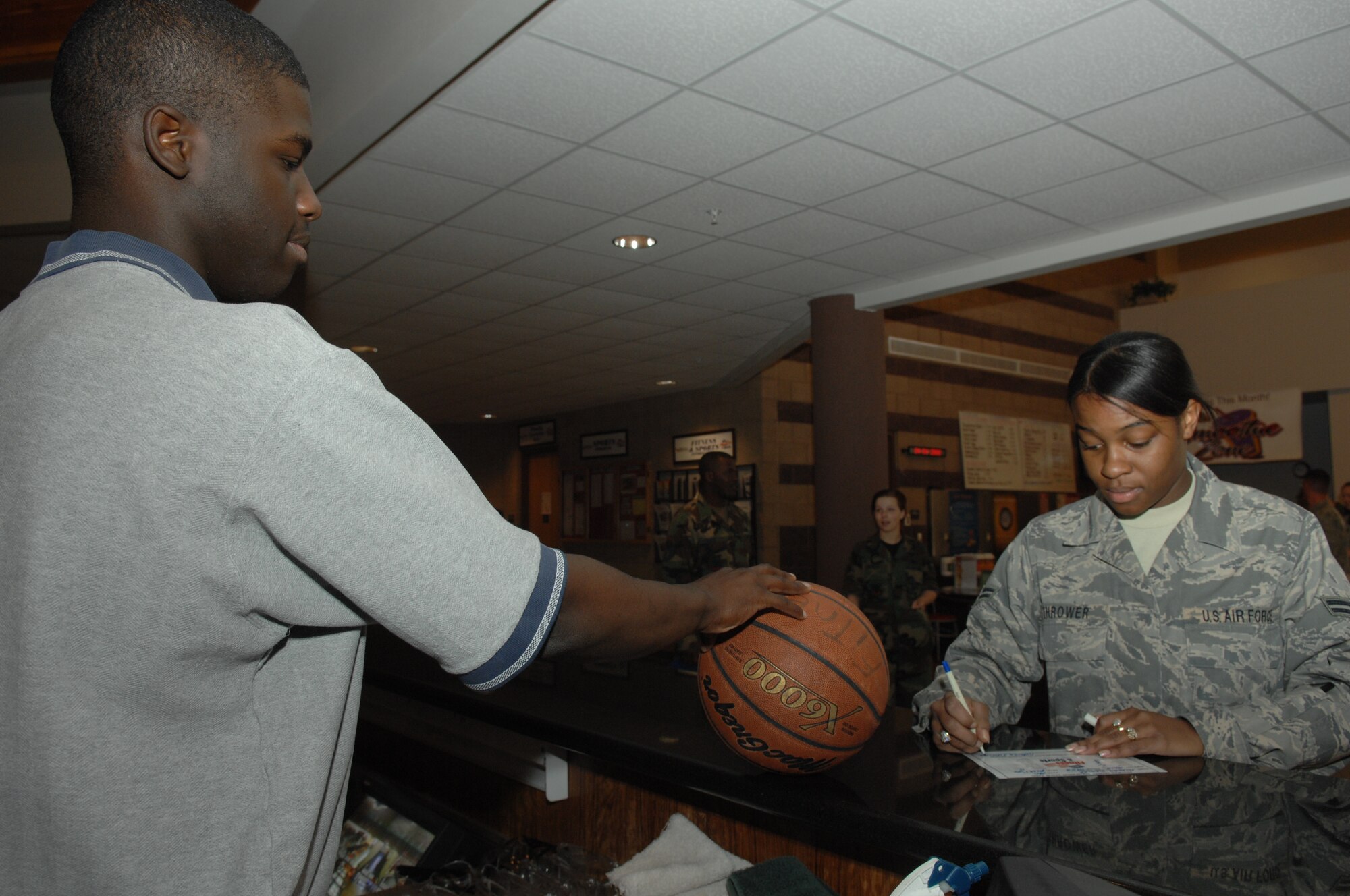 Airman 1st Class Jerome Dorsey signs out a basketball to Airman 1st Class Natasha Thrower April 4, at the fitness center on Holloman Air Force Base, N.M. Both Airman are assigned to the 49th Force Support Squadron. 
(U.S. Air Force photo/Senior Airman Anthony Nelson Jr)
