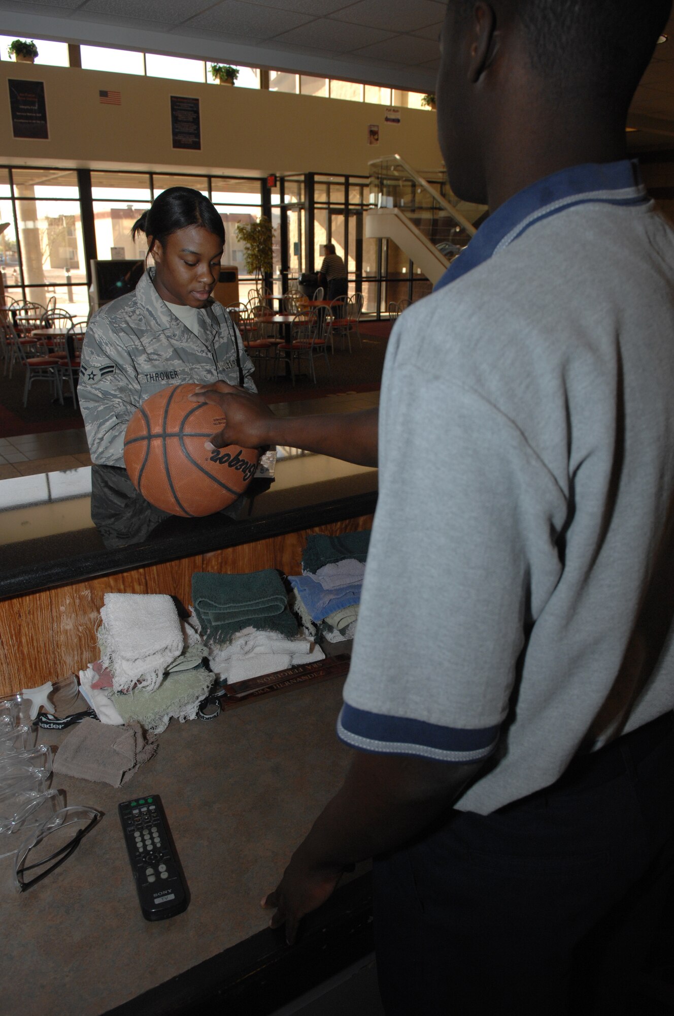 Airman 1st Class Jerome Dorsey signs out a basketball to Airman 1st Class Natasha Thrower April 4, at the fitness center on Holloman Air Force Base, N.M. Both Airman are assigned to the 49th Force Support Squadron. 
(U.S. Air Force photo/Senior Airman Anthony Nelson Jr)