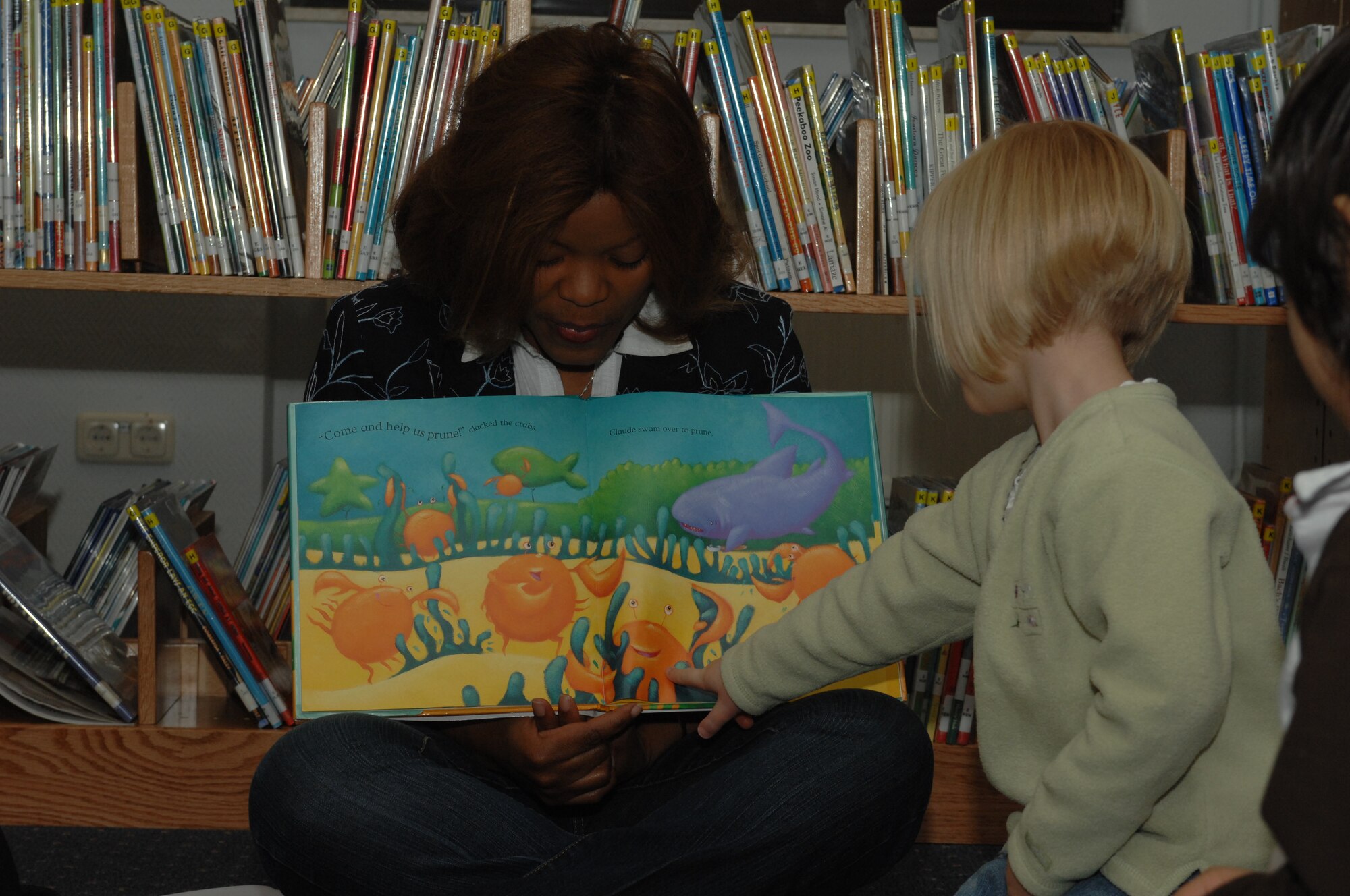 SPANGDAHLEM AIR BASE, Germany -- Maren Matthews, 3, daughter of Amy and Staff Sgt. Chris Matthews, 52nd Component Maintenance Squadron, points to sea creatures while Carmen Gonzalez reads during Children's Reading Hour held at the Spangdahlem AB Library, April 3rd, 2008. (U.S. Air Force photo/Staff Sgt. Kristin Ruleau) 