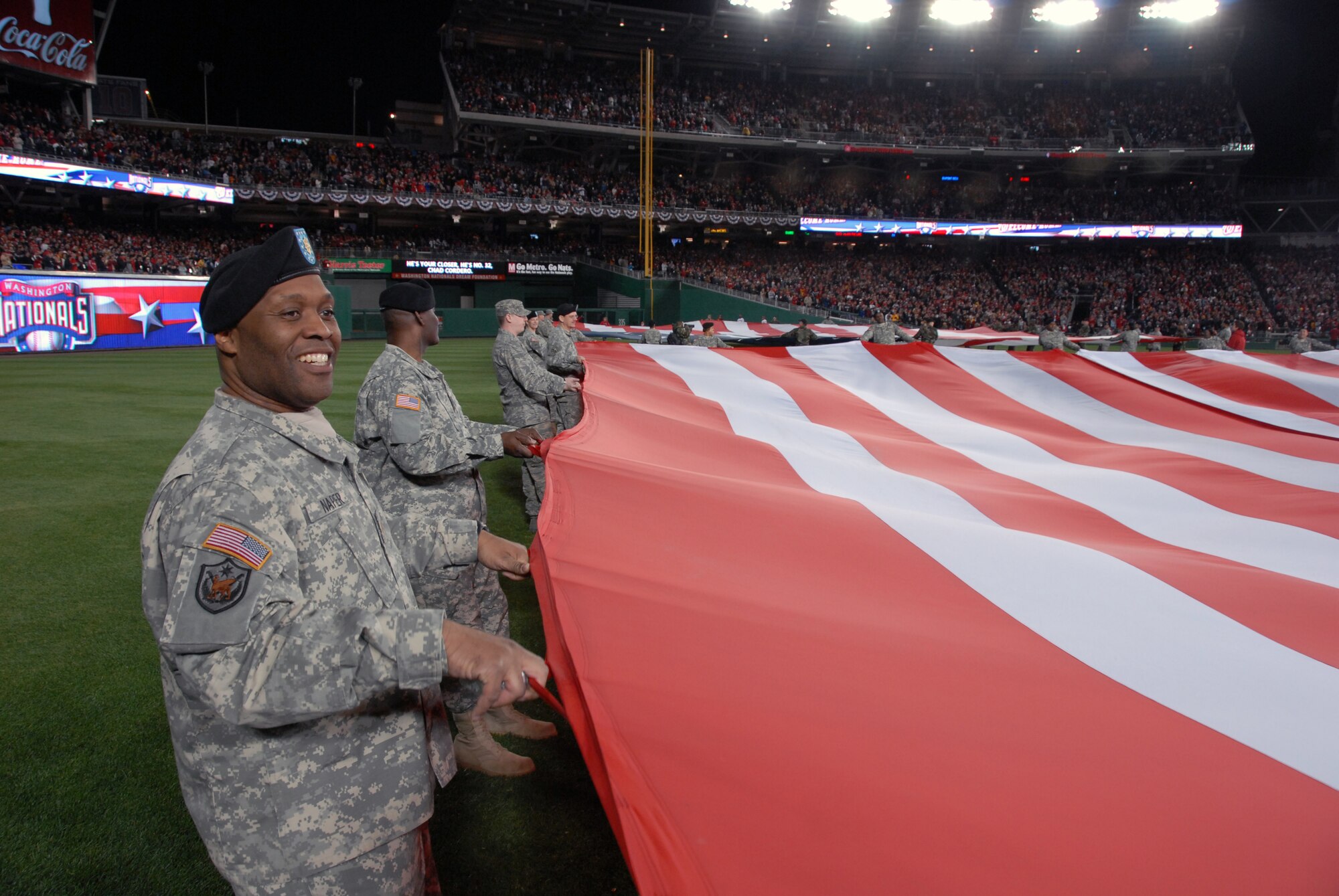 Maj. Bernard Napier, with the D.C. National Guard?s 74th Troop Command, holds one of two giant American flags unfurled on the outfield during pre-game ceremonies for the Inaugural Game at Nationals Park in Washington, D.C., on March 30, 2008. The D.C. Air National Guard's 121st Fighter Squadron also provided an F-16 Fighting Falcon flyover. (U.S. Army photo by Staff Sgt. Jim Greenhill) (Released)
