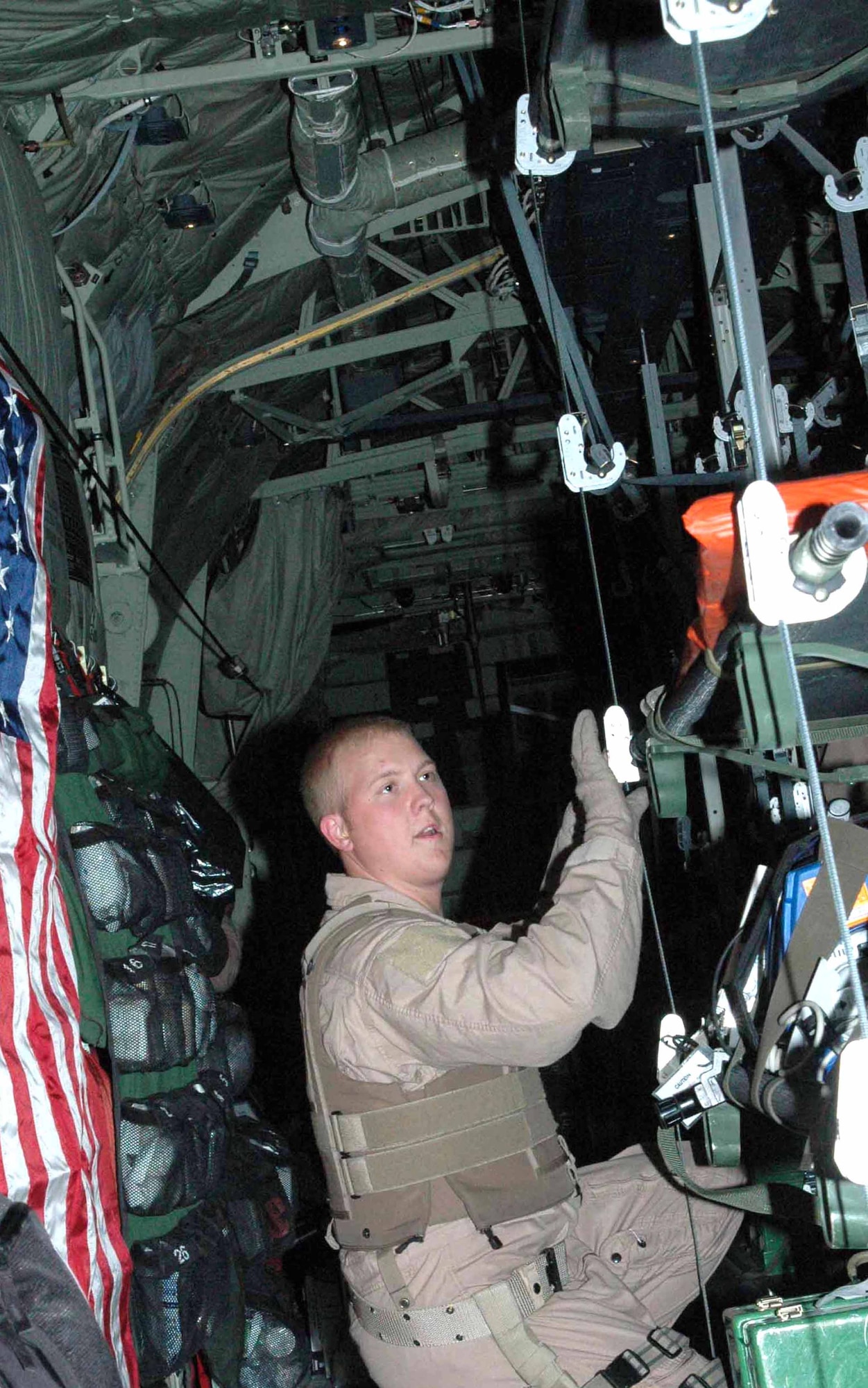 Tech. Sgt. Ken Bullock, 379th EAES second medical technician, prepares litters to receive patients on board a C-130J over Iraq. Sergeant Bullock is an Air National Guard member deployed here from the 183rd AES in Jackson, Miss. He was part of a five-stop combat aeromedical evacuation mission April 2. Crew members on- and off-loaded 19 patients, most of whom were ambulatory, to get medical care either in Southwest Asia or in Germany via Kuwait. (U.S. Air Force photo by Senior Airman Carolyn Viss) 