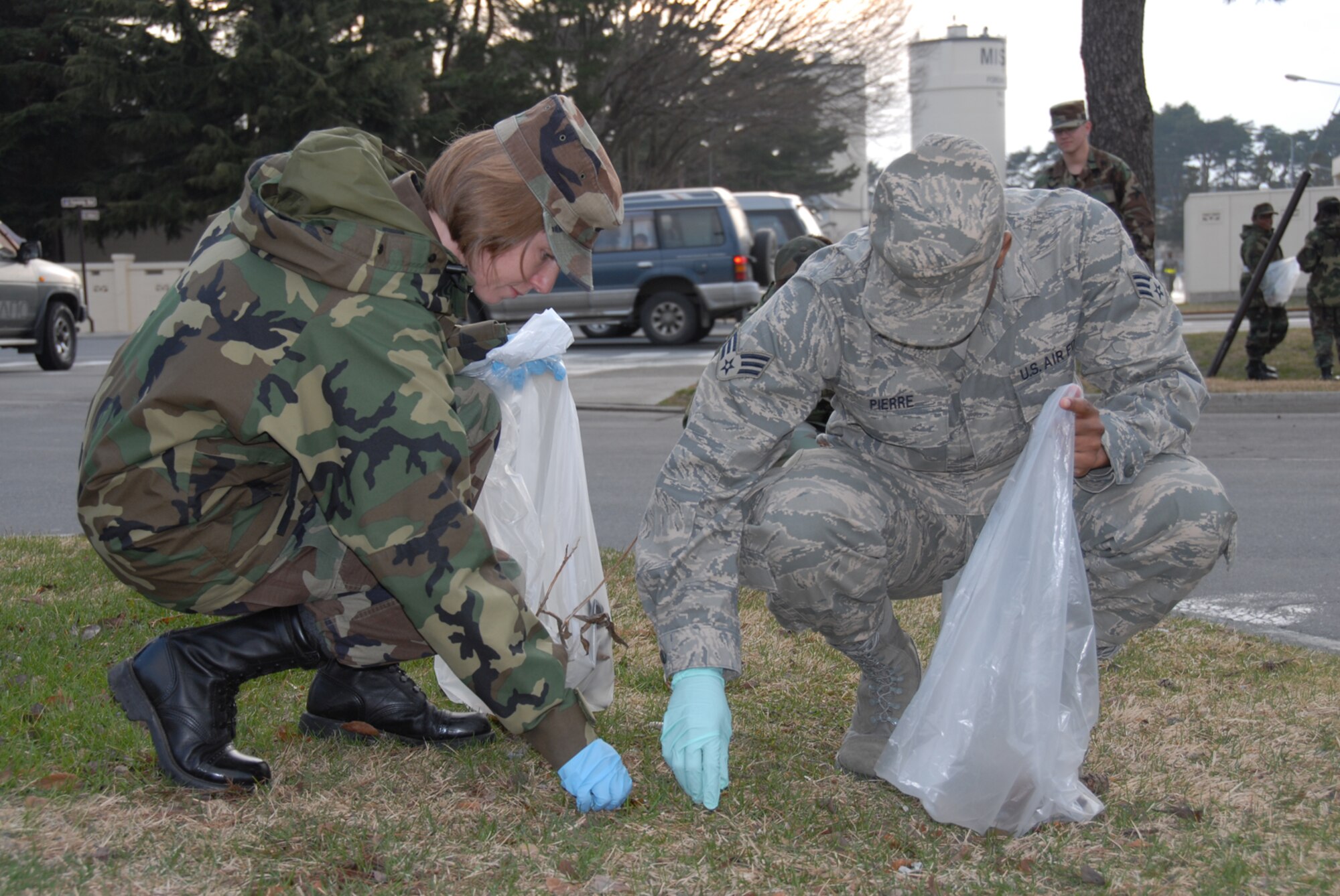 MISAWA AIR BASE, Japan -- Master Sgt. Julie Branco (left) works alongside Senior Airman Allan Pierre (right), both from the 35th Medical Support Squadron, during the annual base clean up here, Apr. 3, 2008.  Misawa holds a yearly base clean up shortly after the last snow melts which gives every squadron a chance to get out and help clean up the base.  (U.S. Air Force photo by Senior Airman Laura R. McFarlane)