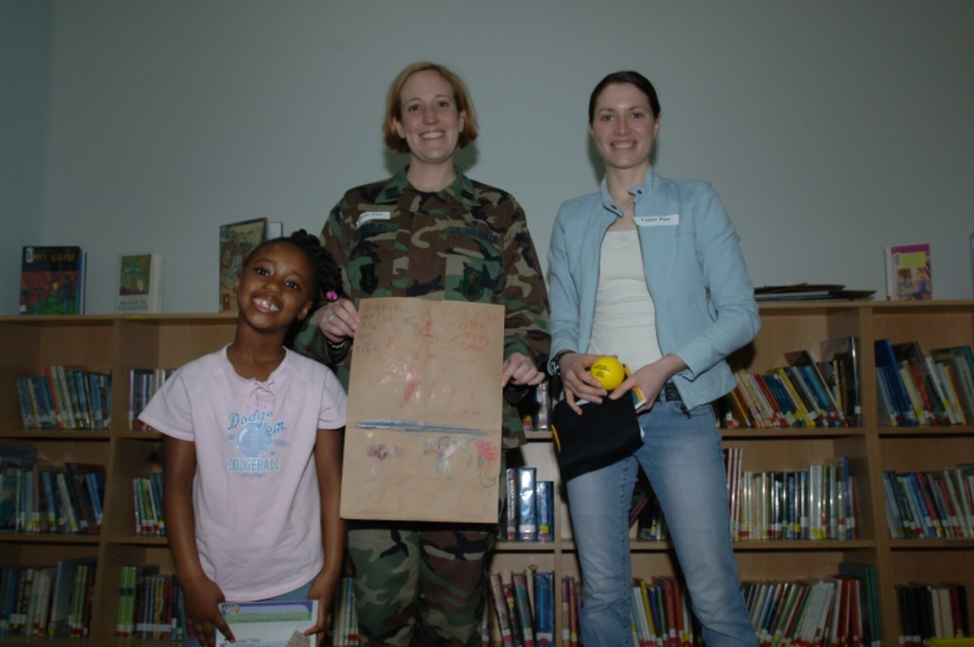 MISAWA AIR BASE, Japan -- Maliya Tilley is awarded first place for kindergarten in the National Nutrition Month coloring contest by Capt. Jennifer Bradley of the 35th Aerospace Medicine Squadron and volunteer Christine Lyon at the Sollars Elementary school library April 3, 2008.  The students were asked to research nutrition at www.eatright.org (U.S. Air Force photo by Senior Airman Robert Barnett)