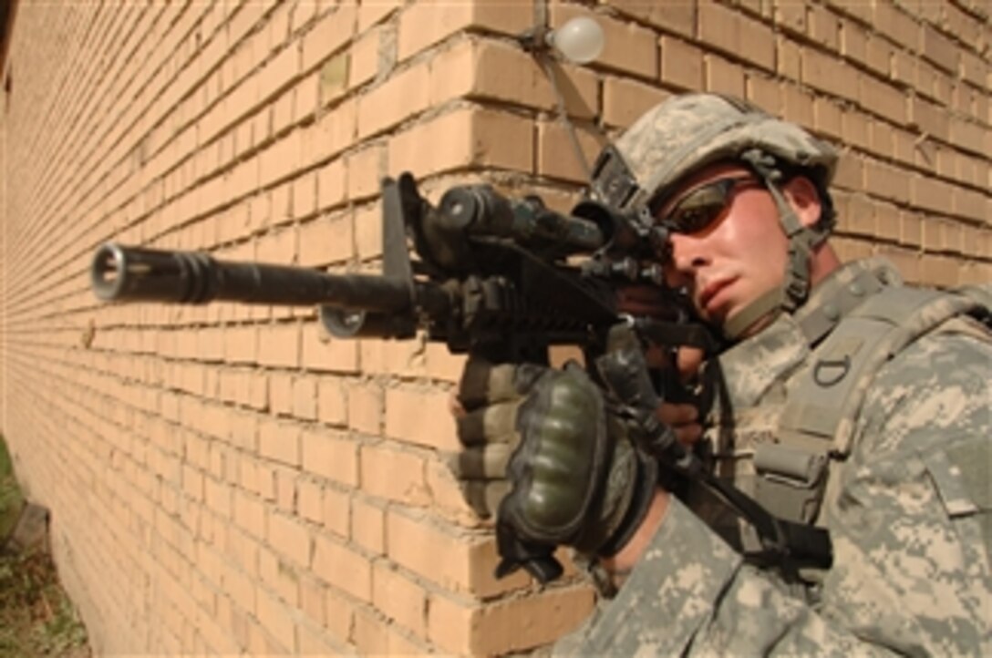 Sgt. Brandon Maybush scans the street through his weapon scope as he provides security for his fellow soldiers during a cordon and search of a factory in Mahmudiyah, Iraq, on April 1, 2008.  Maybush is attached to the U.S. Armyís 320th Battalion, 3rd Brigade Combat Team, 101st Airborne Division.  