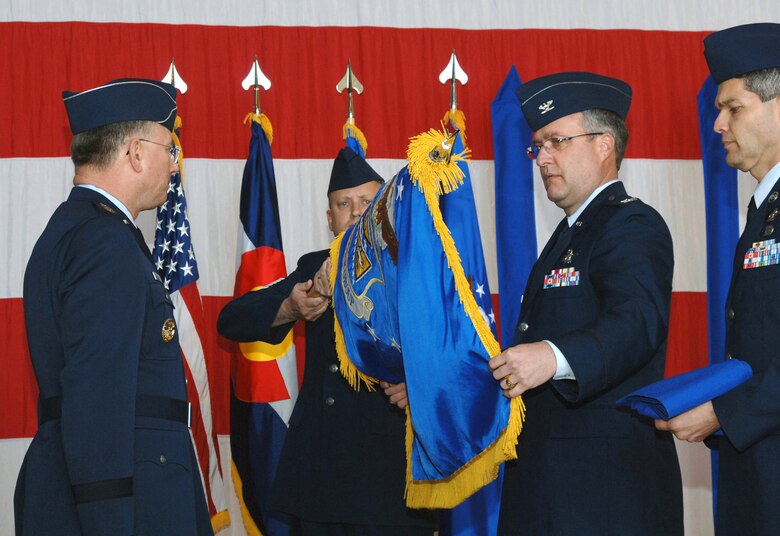 Col. Jeff Ansted (second from right) unfurls the 310th Space Wing colors during an activation ceremony April 4 at Peterson Air Force Base, Colo. Lt. Gen. John A. Bradley, (left) chief of Air Force Reserve and commander of Air Force Reserve Command, officially stood up the AFRC's first-ever space wing.  (U.S. Air Force photo/Amber K. Whittington) 
