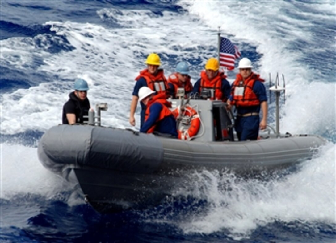 U.S. sailors aboard the guided-missile destroyer USS Nimitz make their way back to the ship in a hulled inflatable boat after rescuing a training dummy, March 22, 2008, during a man overboard drill while under way in the Pacific Ocean.
