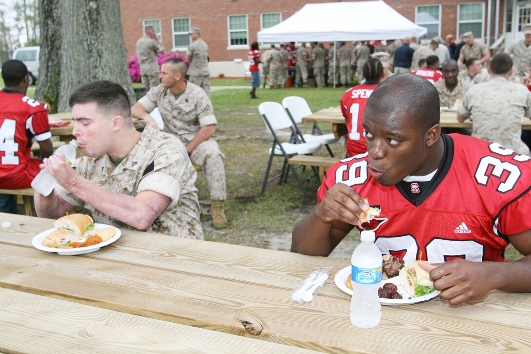 Derrick White, a fullback with the Wolfpack football team, North Carolina State University, Raleigh, N.C., and Lance Cpl. Anson Roberts, a wounded warrior with the Wounded Warrior Battalion-East, Wounded Warrior Regiment, Manpower and Reserve Affairs, enjoy dinner together here April 7.