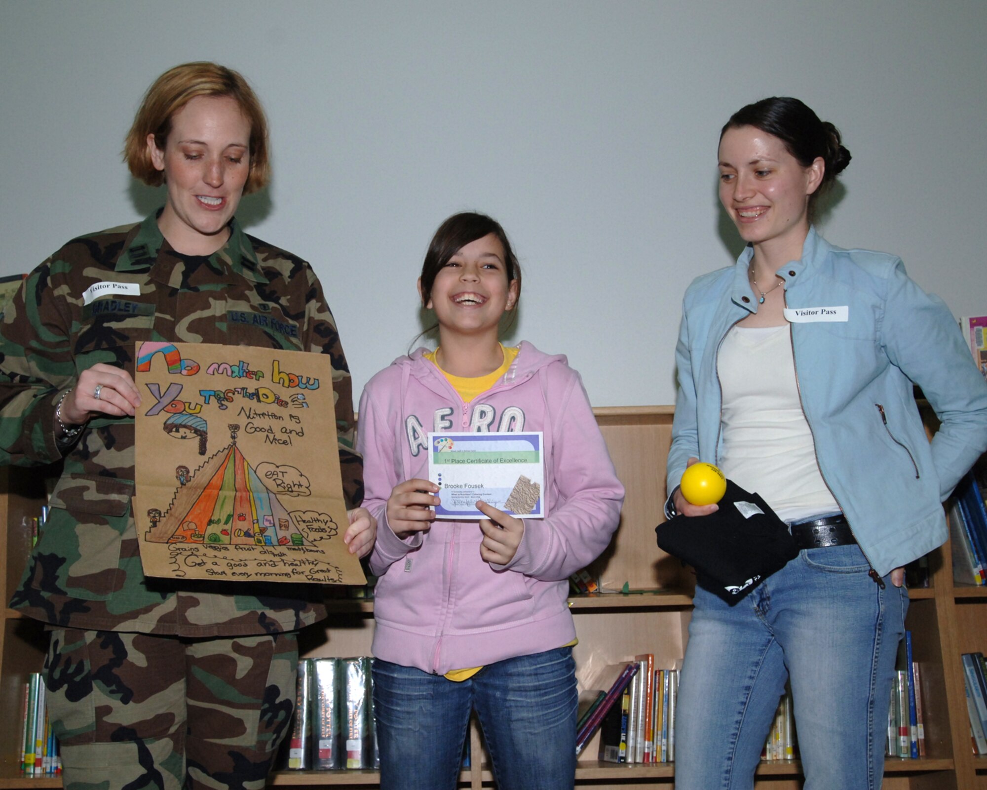 MISAWA AIR BASE, Japan -- Brook Fousek is awarded first place for fifth grade in the National Nutrition Month coloring contest by Capt. Jennifer Bradley of the 35th Aerospace Medicine Squadron and volunteer Christine Lyon at the Sollars Elementary school library April 3, 2008.  The students were asked to draw what nutrition means to them on paper bags, the winners to be hung up in the commissary. (U.S. Air Force photo by Senior Airman Robert Barnett)