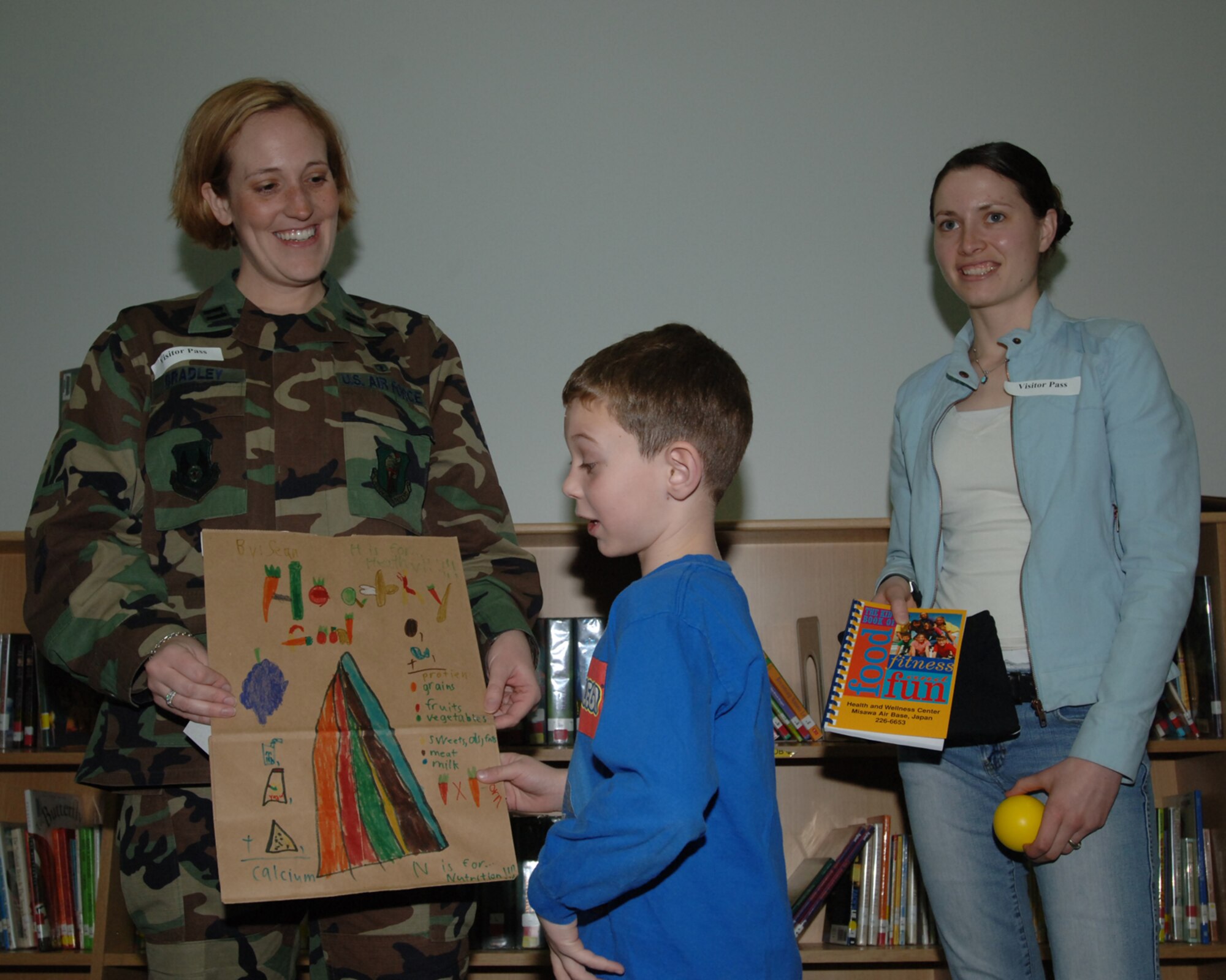 MISAWA AIR BASE, Japan -- Sean Smyth is awarded first place for second grade in the National Nutrition Month coloring contest by Capt. Jennifer Bradley of the 35th Aerospace Medicine Squadron and volunteer Christine Lyon at the Sollars Elementary school library April 3, 2008.  The winners are displayed in the Commissary. (U.S. Air Force photo by Senior Airman Robert Barnett)