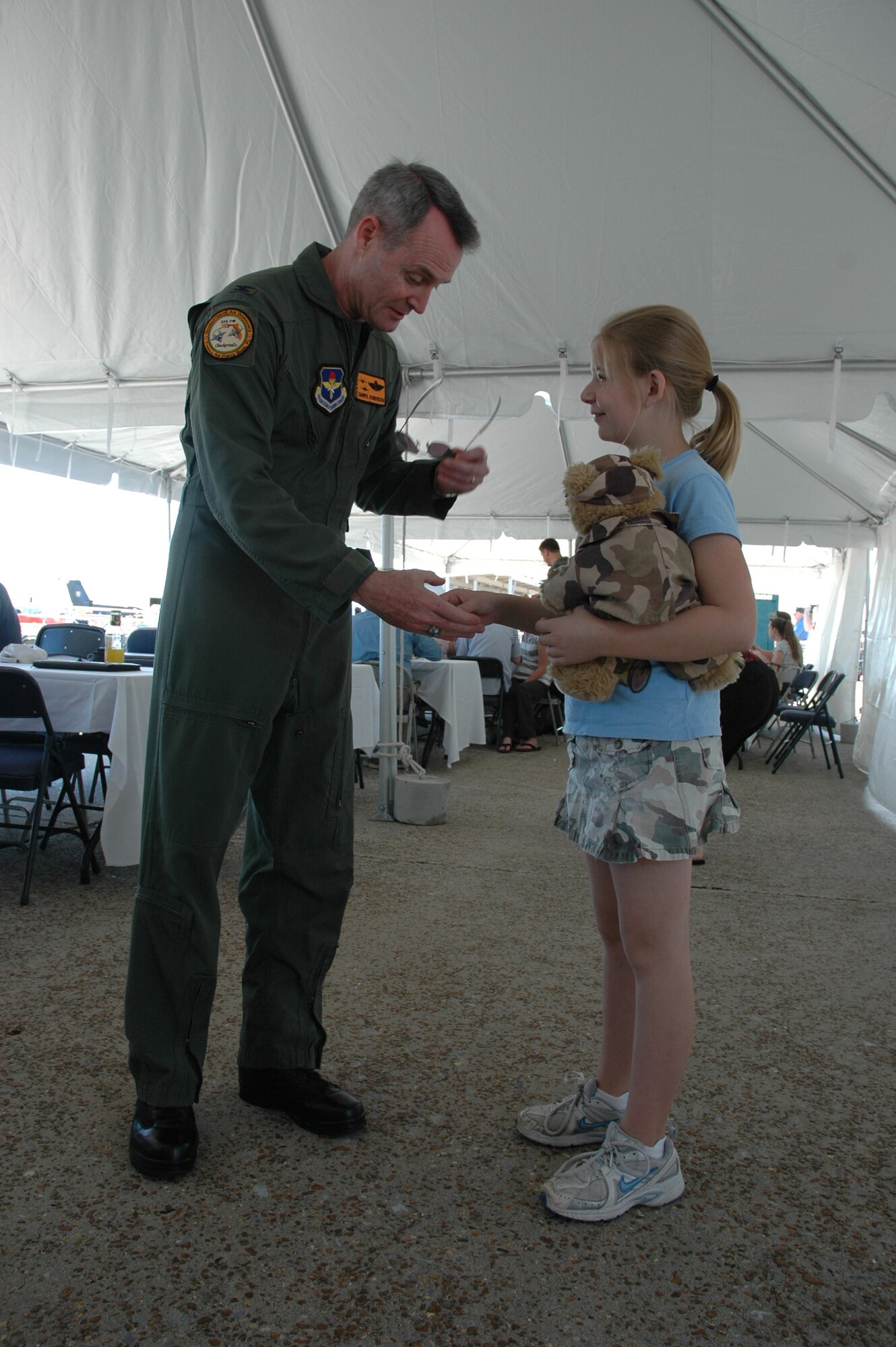 Bailey Reese, Hero Hugs founder and president, "coins" Col. Darryl Roberson, 325th Fighter Wing commander, during the 2008 Gulf Coast Salute for his military service.  