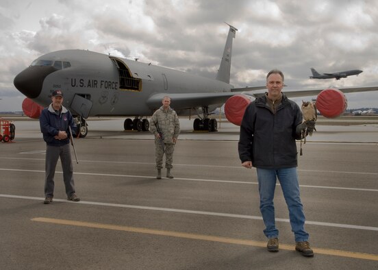 FAIRCHILD AIR FORCE BASE, Wash. – Members of the Bird Aircraft Strike Hazard avoidance program Dave Knutson, contracted falcon trainer and handler, Steven Benson, 92nd Civil Engineer Squadron entomologist, and Tech. Sgt. Joseph Pierce, 92nd Air Refueling Wing flight safety superintendent, pose momentarily for a photo on the airfield here March 1. The BASH program is implemented throughout the Air Force to help reduce the risk for damage to aircraft by local wildlife. (U.S. Air Force photo / Airman 1st Class Joshua Chapman) 