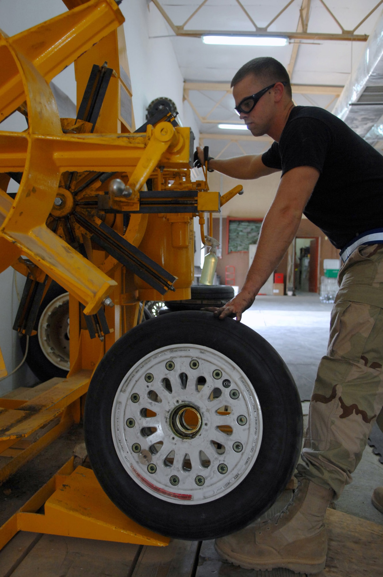Airman 1st Class Jared Hollers places an F-16 Fighting Falcon's wheel onto a bead breaker that separates the tire from the rim at Balad Air Base, Iraq. Replacing the outer skin of the wheel helps provide the proper traction during landings. Airman Hollers is a 332nd Expeditionary Maintenance Squadron crew chief deployed from Hill Air Force Base, Utah. (U.S. Air Force photo/Senior Airman Julianne Showalter) 