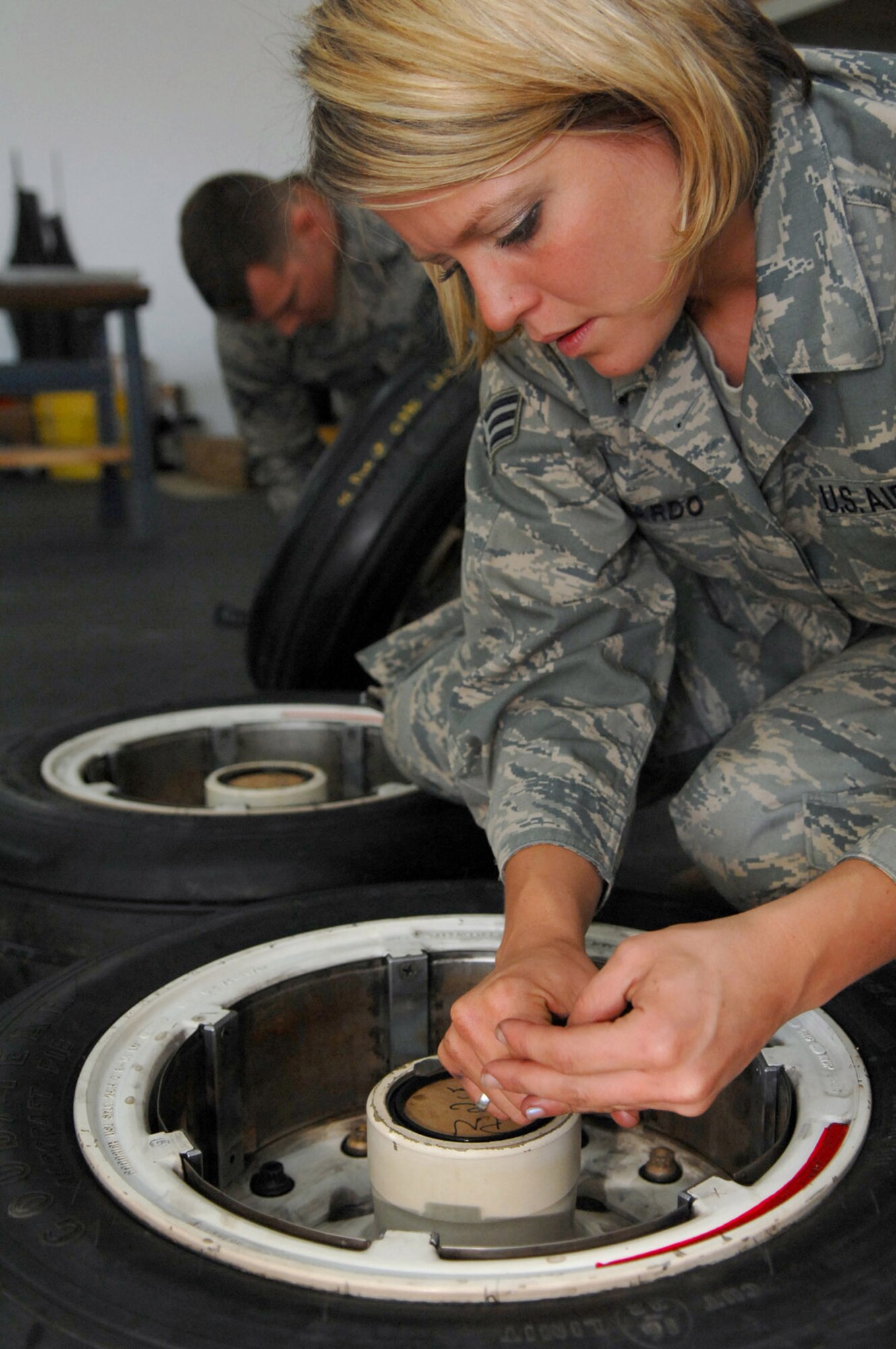 Senior Airman Melissa Gallardo replaces retaining rings on an F-16 Fighting Falcon's main landing gear wheel at Balad Air Base, Iraq. The 332nd Expeditionary Maintenance Squadron provides combat-ready aircraft and munitions to the air component commander in support of coalition forces throughout Iraq. Airman Gallardo is a 332nd EMXS crew chief deployed from the Montana Air National Guard. (U.S. Air Force photo/Senior Airman Julianne Showalter) 