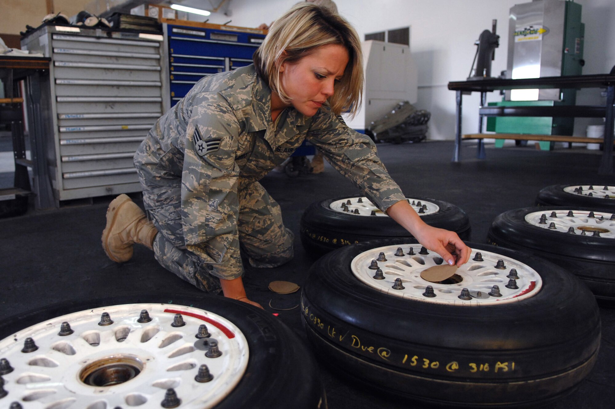 Senior Airman Melissa Gallardo places dust covers over the retaining rings on an F-16 Fighting Falcon's main landing gear wheel at Balad Air Base. Changing an aircraft's tires frequently ensures the aircraft has the required traction needed during landings. Airman Gallardo is a 332nd Expeditionary Maintenance Squadron crew chief deployed from the Montana Air National Guard. (U.S. Air Force photo/Senior Airman Julianne Showalter) 