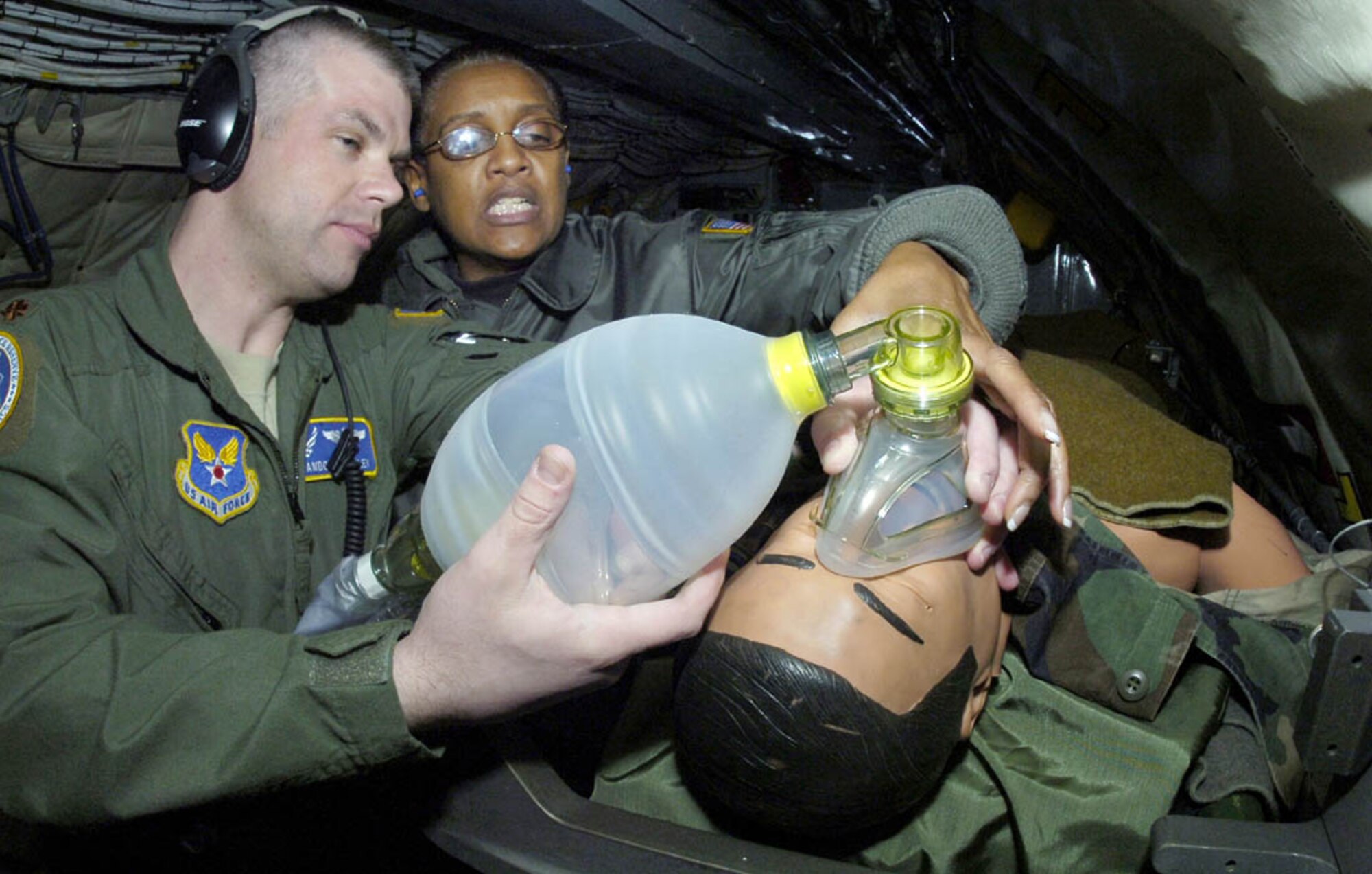 ANDREWS AIR FORCE BASE, Md. -- Lt. Col. Vanessa Mattox, 459th Aeromedical Evacuation Squadron commander, trains Maj. Brandon L. Bailey, 459th AES flight nurse, on how to ensure a bag valve mask is sealed at the mouth of "Trauma Tom," a 195-pound dummy, during a simulated medical in-flight emergency training exercise. (U.S. Air Force photo/Bobby Jones)