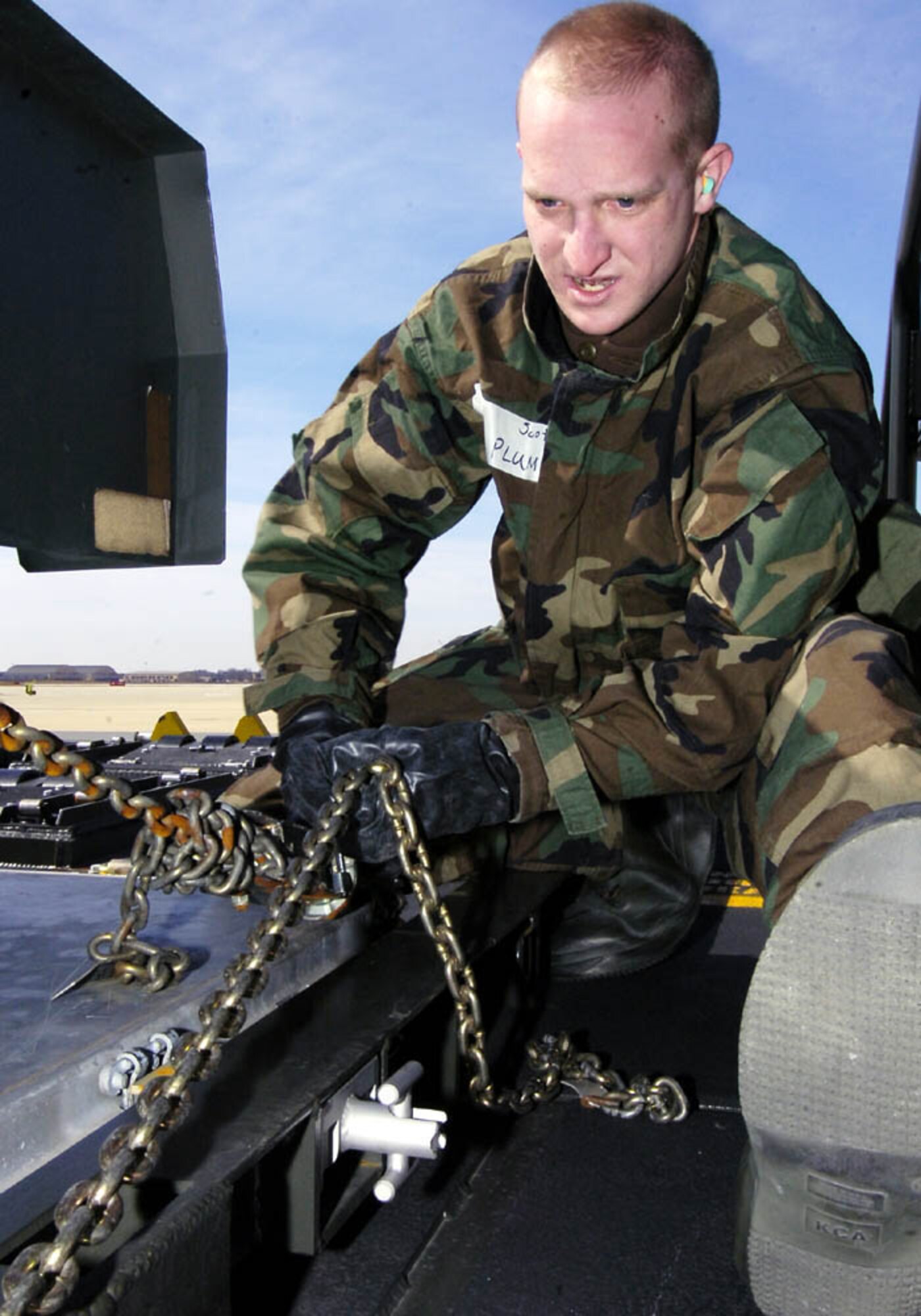 ANDREWS AIR FORCE BASE, Md. -- Senior Airman Scott Plum, 69th Aerial Port Squadron air transportation journeyman, uses chains and devices to tie down a 6000-pound generator on to the flat bed of a next-generation small loader March 2. (U.S. Air Force photo/Bobby Jones)