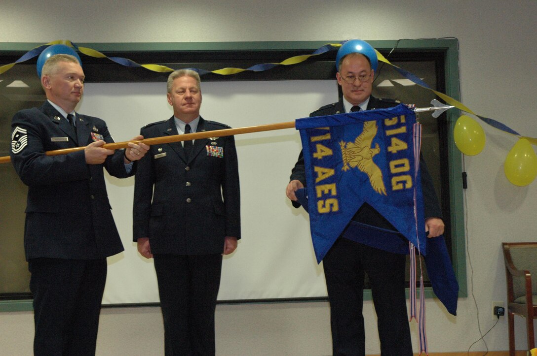 MCGUIRE AIR FORCE BASE , N.J. -- First Sergeant Senior Master Sgt. Eric Griffin, left, furls the 714th Aeromedical Evacuation Squadron flag  March 29 during the unit's deactivation ceremony.  He is assisted by unit commander, Lt. Col. Bruce Adams, right, while Col. Bruce Bowers, commander, 514th Operations Group watches. The Air Force Reserve unit, tasked to provide worldwide in-flight medical aid to the sick and injured, ends 14 years of activation at McGuire Air Force Base. N.J. 