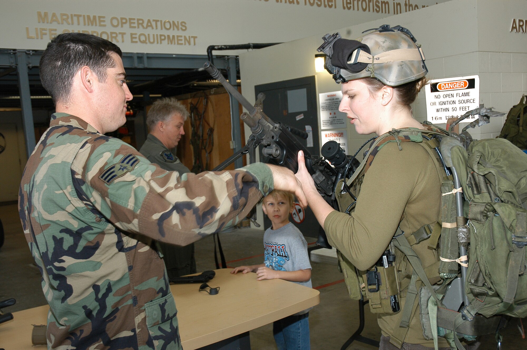 Joleen Baker (right) takes a closer look at a squad automatic weapon, with help from a combat controller from the 320th Special Tactics Squadron during the Air Commando Spouses Day at the 353rd Special Operations Group April 4.