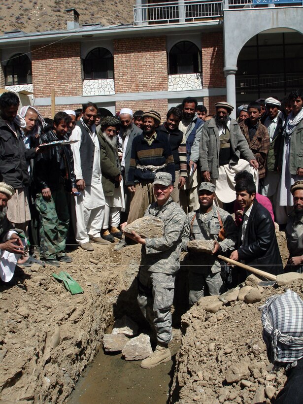 PANJSHIR, Afghanistan -- Capts. Jason M. Aftanas and Kenneth McGinnis, Panjshir Provincial Reconstruction Team engineers, prepare to set stones for the foundation of the Khenj District’s Justice Center during a ceremony April 1. The engineers placed the commemorative stones beside those laid by the District’s Chief Justice Mohammad Yousef Qata. The $220,000 building is expected to be complete in January 2009 and furthers one of the key tenets of the PRT mission -- governance. (U.S. Air Force photo by Capt. Jillian Torango)